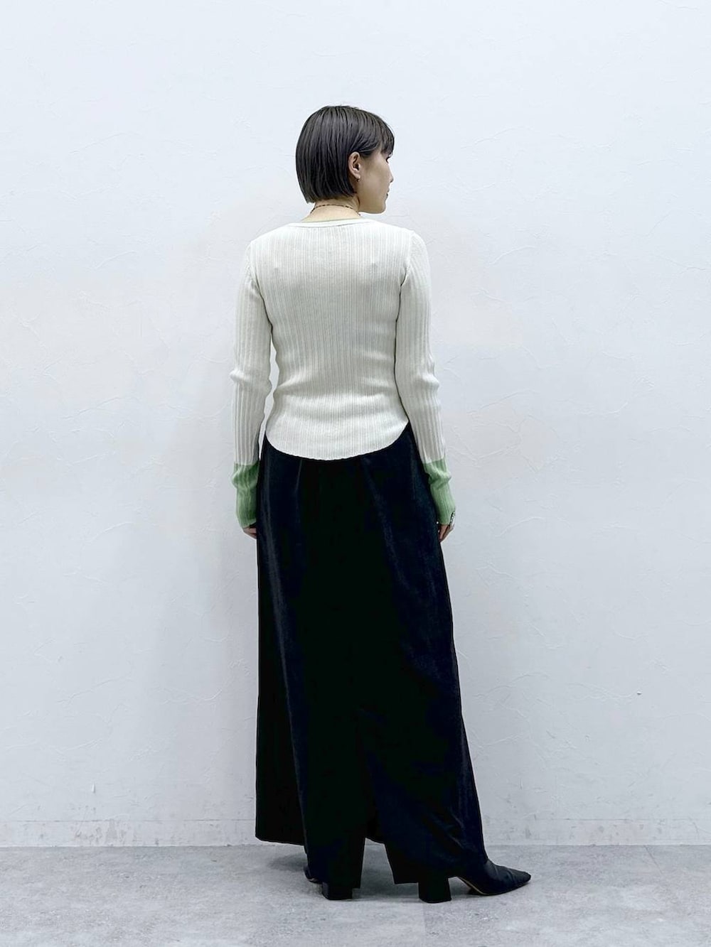 ブラック系のスカート、ホワイト系のニット/セーターを着用したレディースの春コーディネートの6枚目の写真