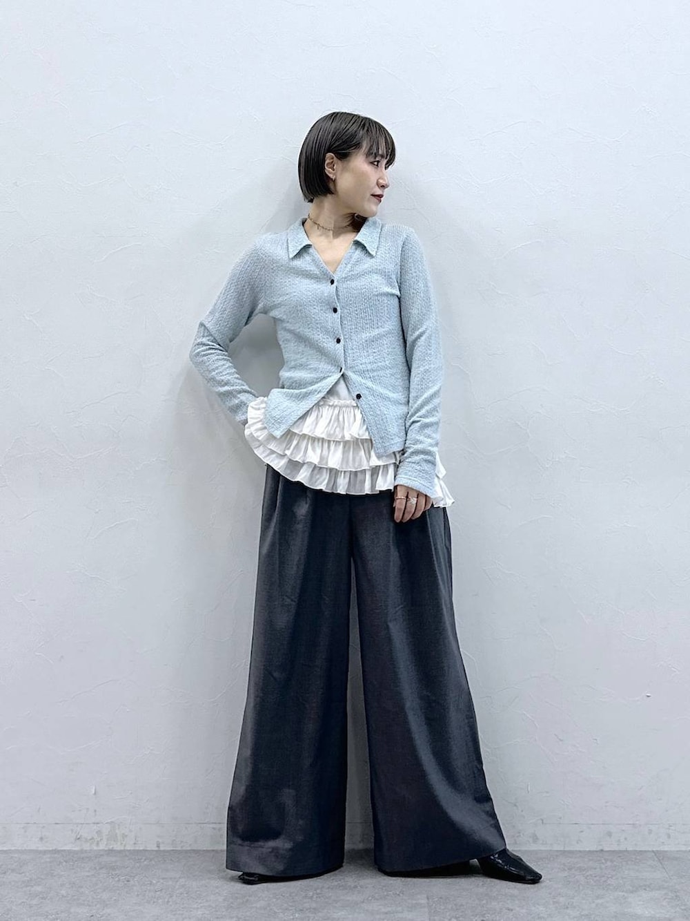 ホワイト系のキャミソール、グレー系のスラックス、ブルー系のカーディガン/ボレロを着用したレディースの春コーディネートの2枚目の写真