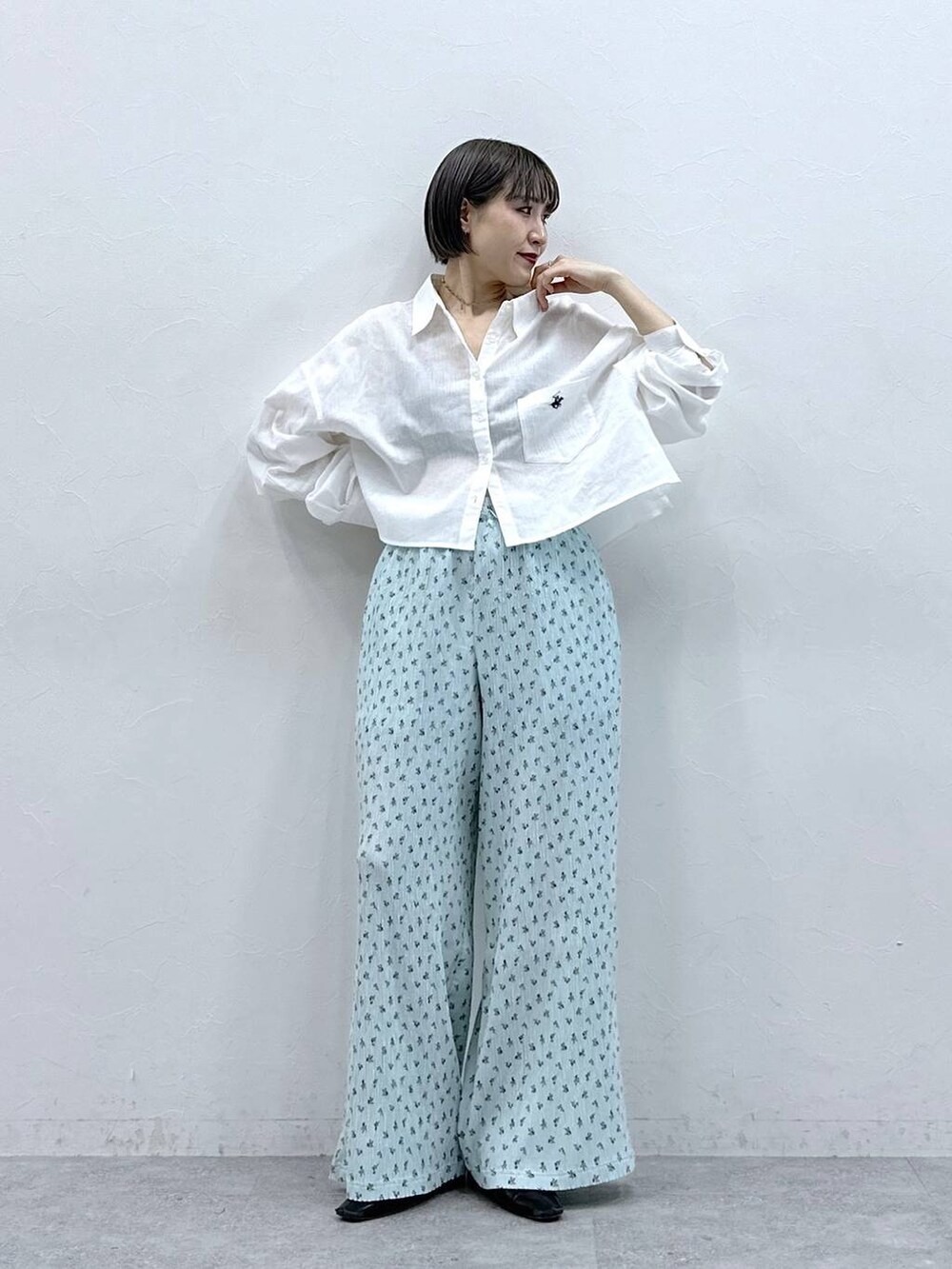 ホワイト系のシャツ/ブラウス、ブルー系のスラックスを着用したレディースの春コーディネートの2枚目の写真