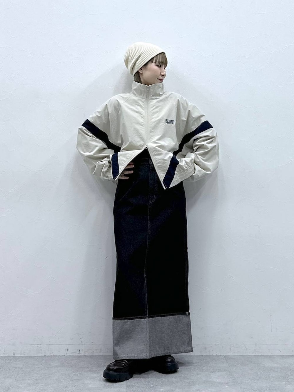 ブラック系のローファー、ホワイト系のブルゾン、ブラック系のデニムスカートを着用したレディースの冬コーディネートの3枚目の写真