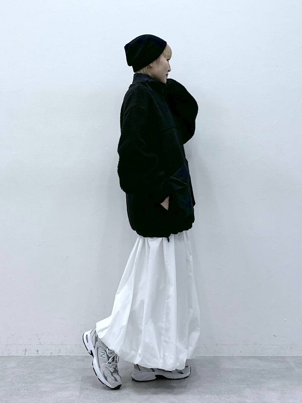 ブラック系のブルゾン、ホワイト系のスカートを着用したレディースの冬コーディネートの3枚目の写真