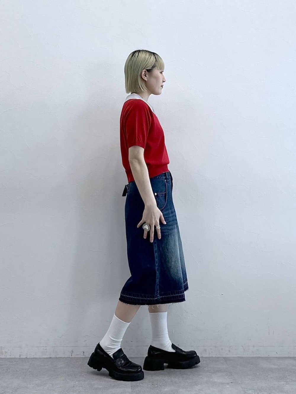 ブルー系のデニムパンツ、ブラック系のローファー、レッド系のポロシャツを着用したレディースの夏コーディネートの4枚目の写真