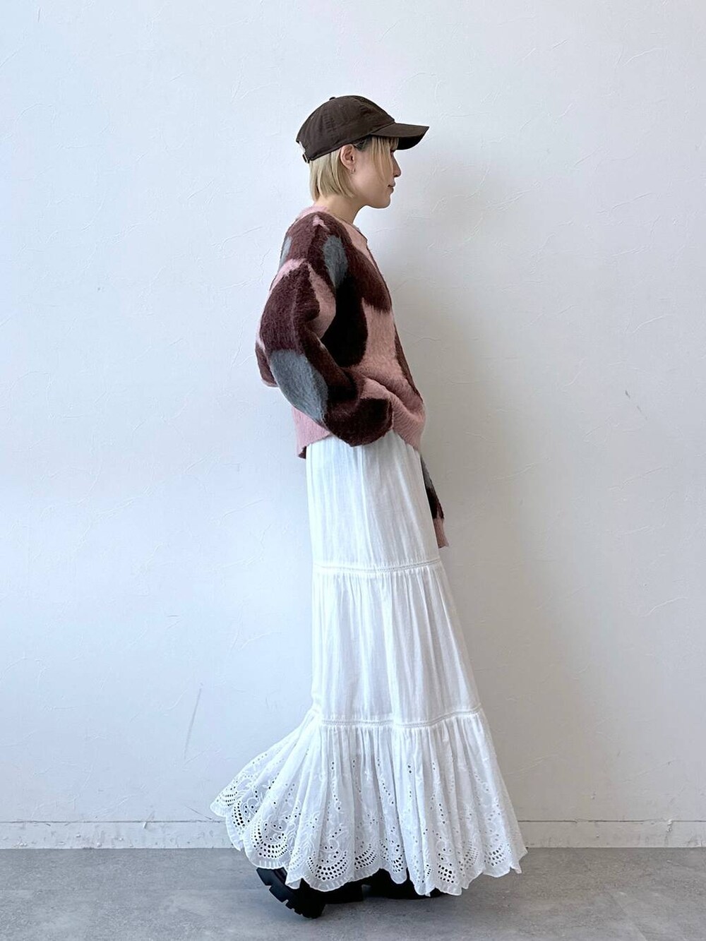 ブラック系のローファー、ピンク系のニット/セーター、ホワイト系のスカートを着用したレディースの秋コーディネートの5枚目の写真