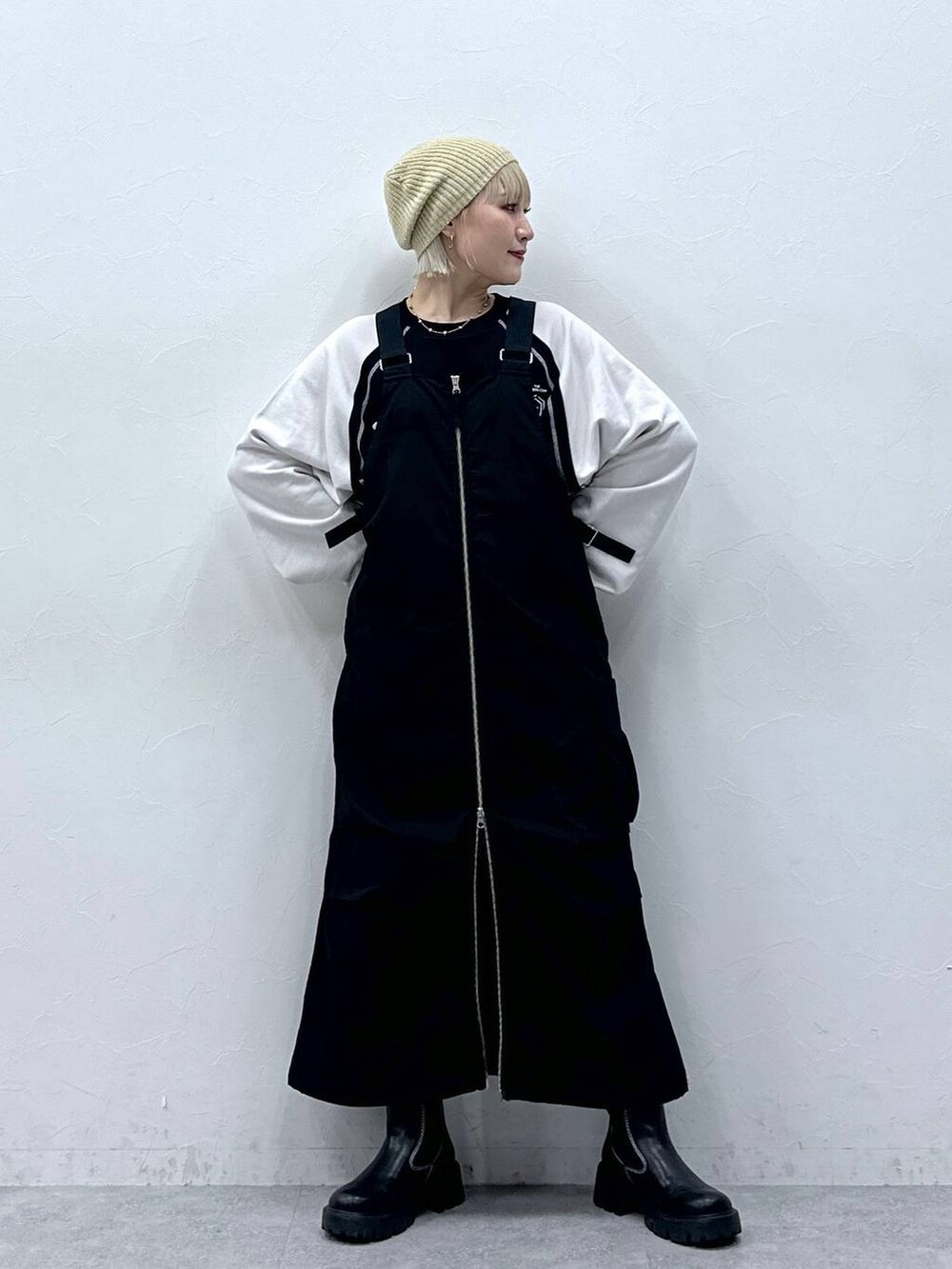 ブラック系のジャンパースカート、ブラック系のスウェット、ベージュ系のハンチング/ベレー帽を着用したレディースの秋コーディネートの3枚目の写真