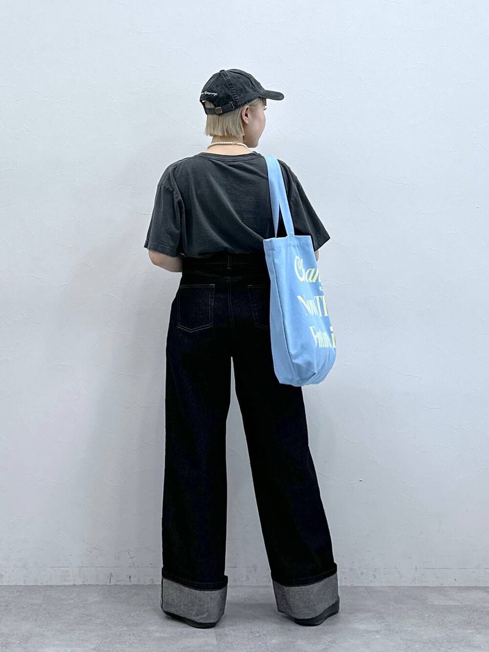 ブラック系のTシャツ/カットソー、ブラック系のデニムパンツ、ピンク系のトートバッグを着用したレディースの夏コーディネートの6枚目の写真