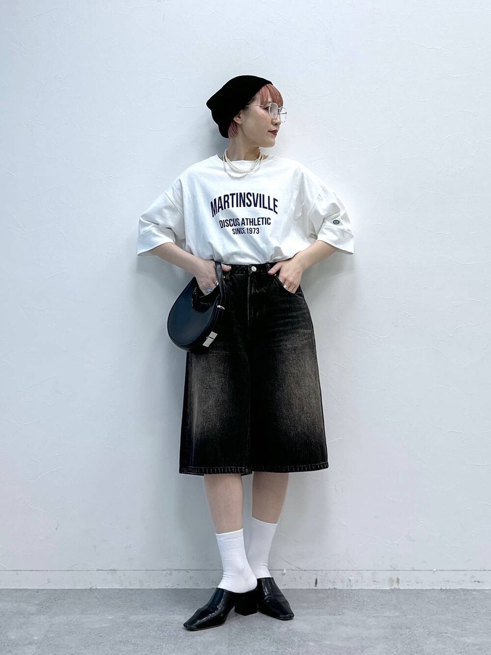 ブラック系のデニムパンツ、ホワイト系のTシャツ/カットソーを着用したレディースの春コーディネートの2枚目の写真