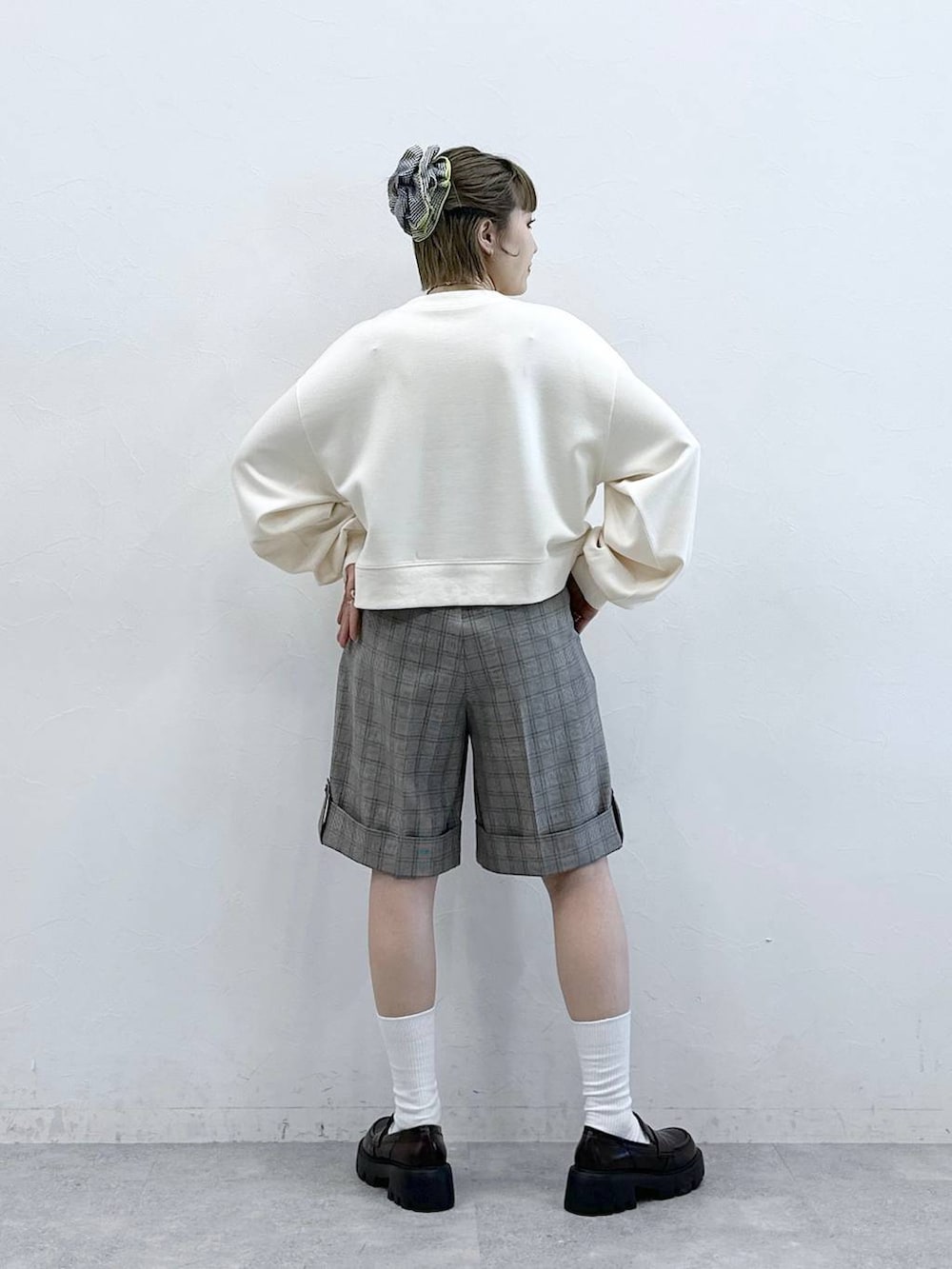 ブラック系のローファー、ホワイト系のスウェット、ベージュ系のスラックスを着用したレディースの冬コーディネートの6枚目の写真