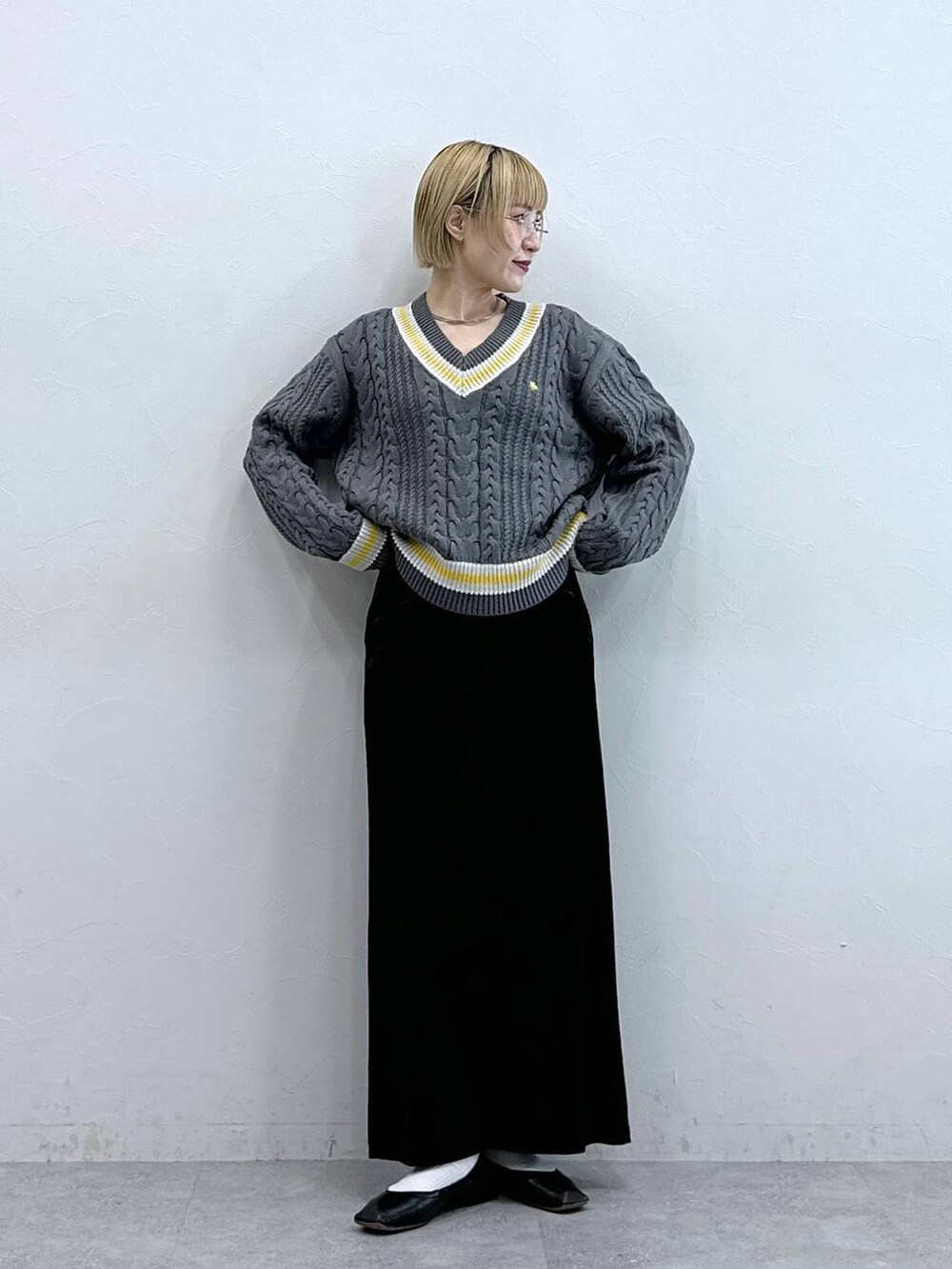 グレー系のニット/セーター、ブラック系のスカートを着用したレディースの秋コーディネートの4枚目の写真