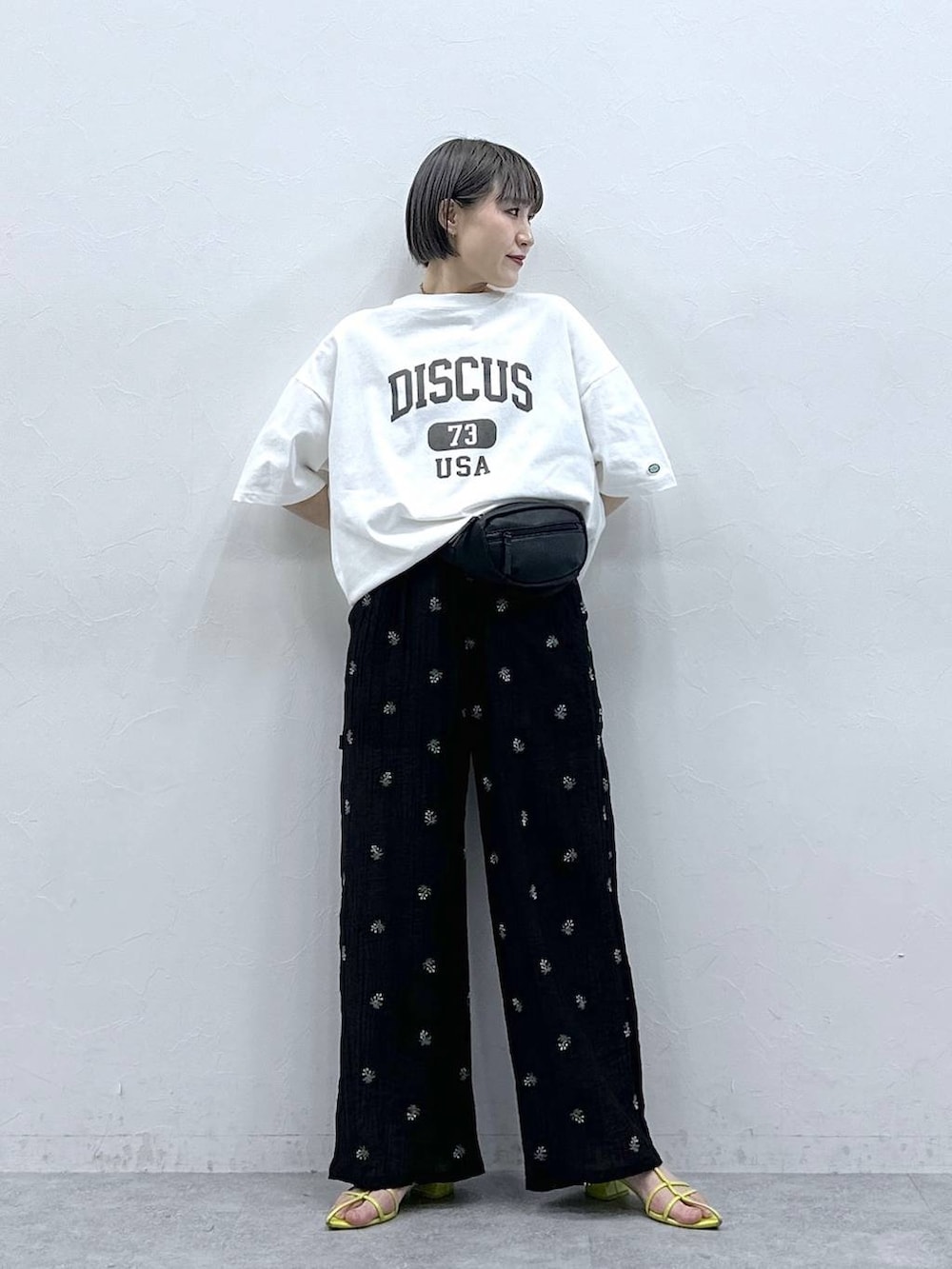 ホワイト系のTシャツ/カットソー、ブラック系のボディバッグ/ウエストポーチ、ブラック系のスラックスを着用したレディースの春コーディネートの3枚目の写真