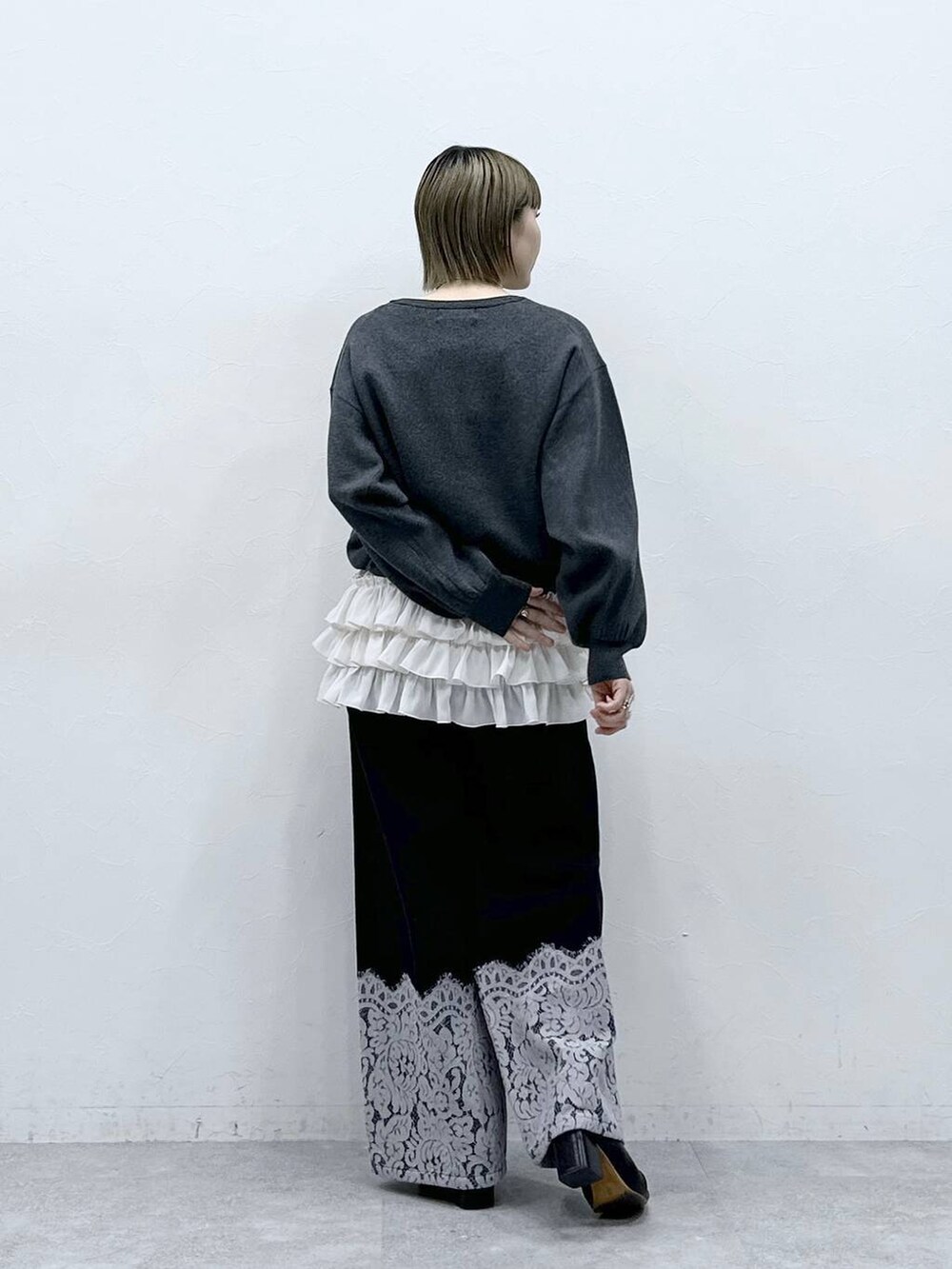 ホワイト系のキャミソール、グレー系のカーディガン/ボレロ、ブラック系のデニムパンツを着用したレディースの冬コーディネートの5枚目の写真