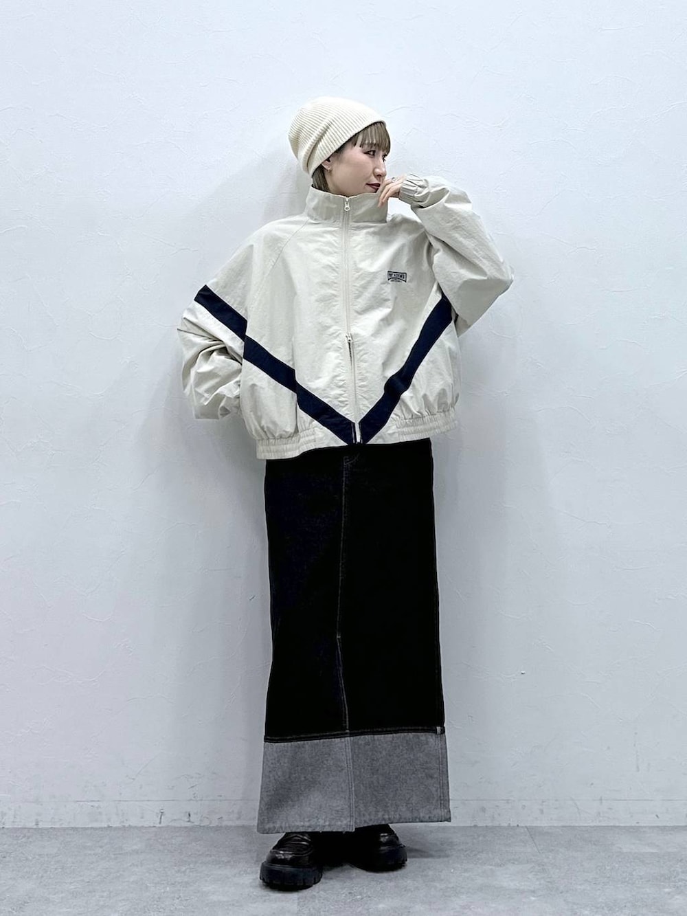 ブラック系のローファー、ホワイト系のブルゾン、ブラック系のデニムスカートを着用したレディースの冬コーディネートの2枚目の写真
