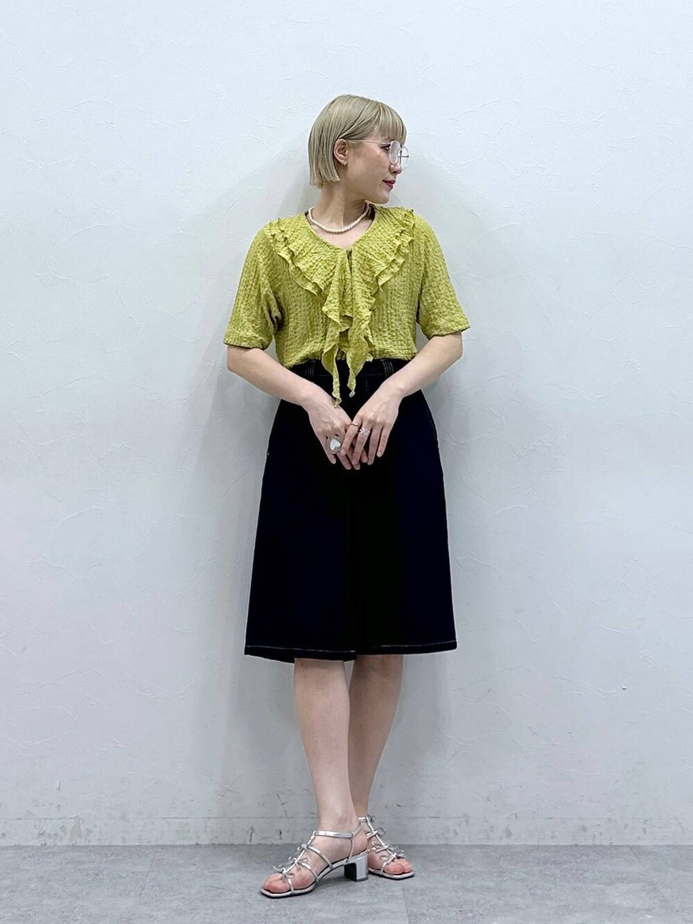 イエロー系のシャツ/ブラウス、ブルー系のデニムパンツ、ブラック系のメガネを着用したレディースの夏コーディネートの3枚目の写真