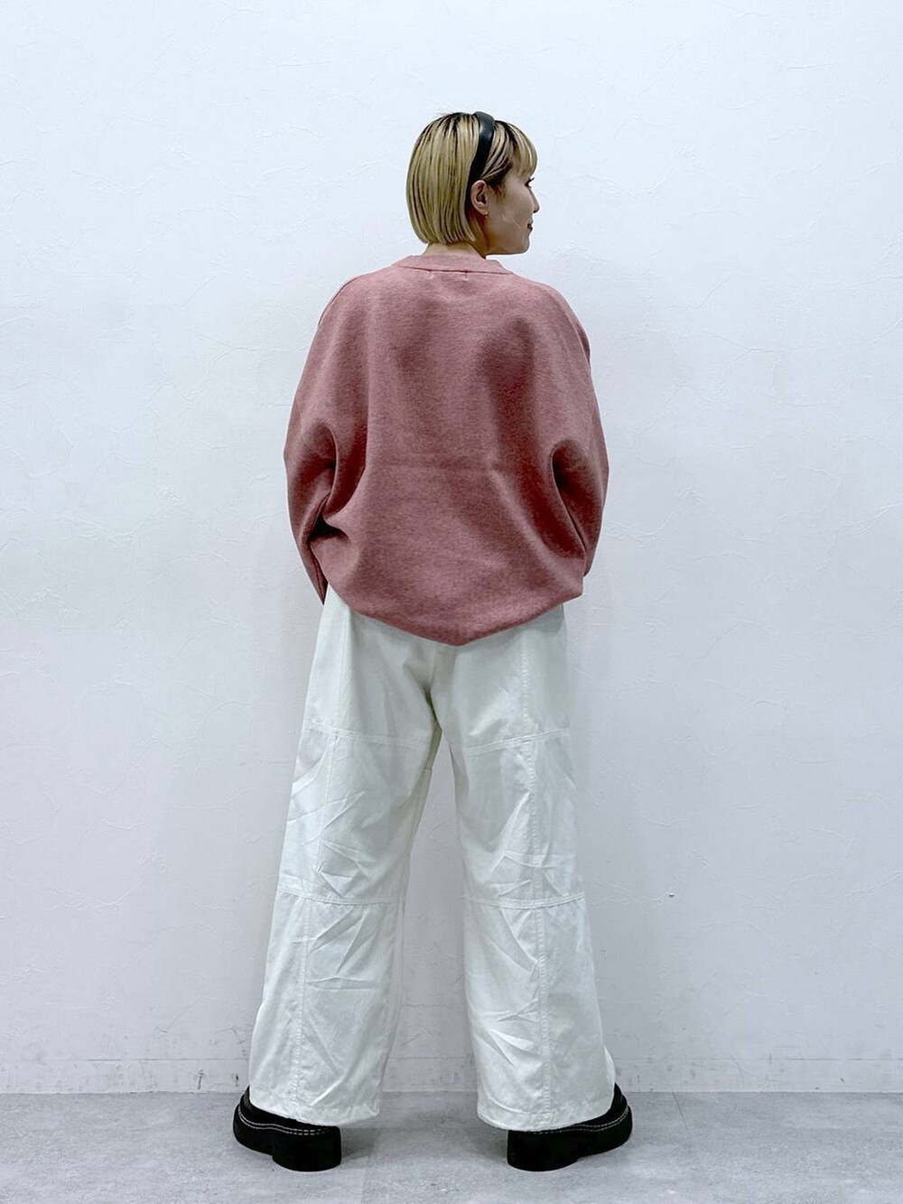 ブラック系のローファー、ホワイト系のカーゴパンツ、ピンク系のニット/セーターを着用したレディースの冬コーディネートの5枚目の写真