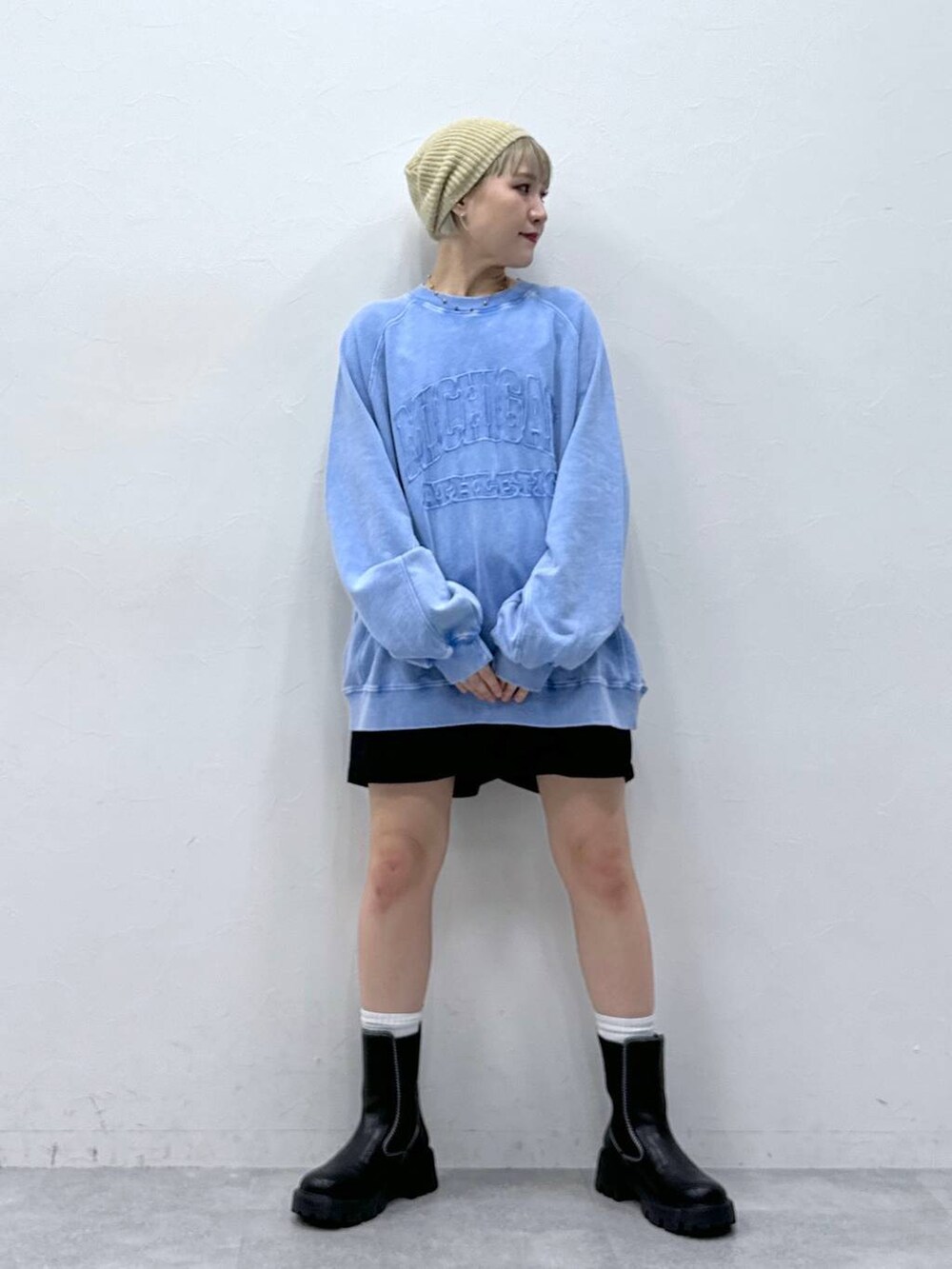 ブラック系のチノパンツ、ブラック系のブーツ、ブルー系のスウェットを着用したレディースの秋コーディネートの6枚目の写真