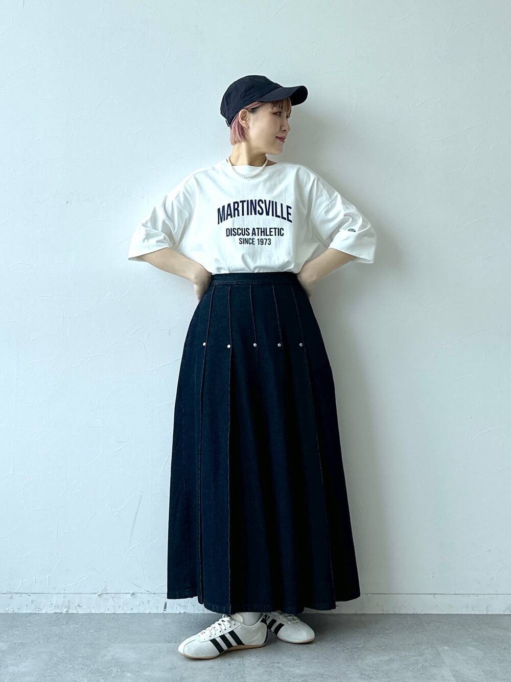 ホワイト系のTシャツ/カットソー、ホワイト系のスニーカー、ブルー系のデニムスカートを着用したレディースの春コーディネートの4枚目の写真