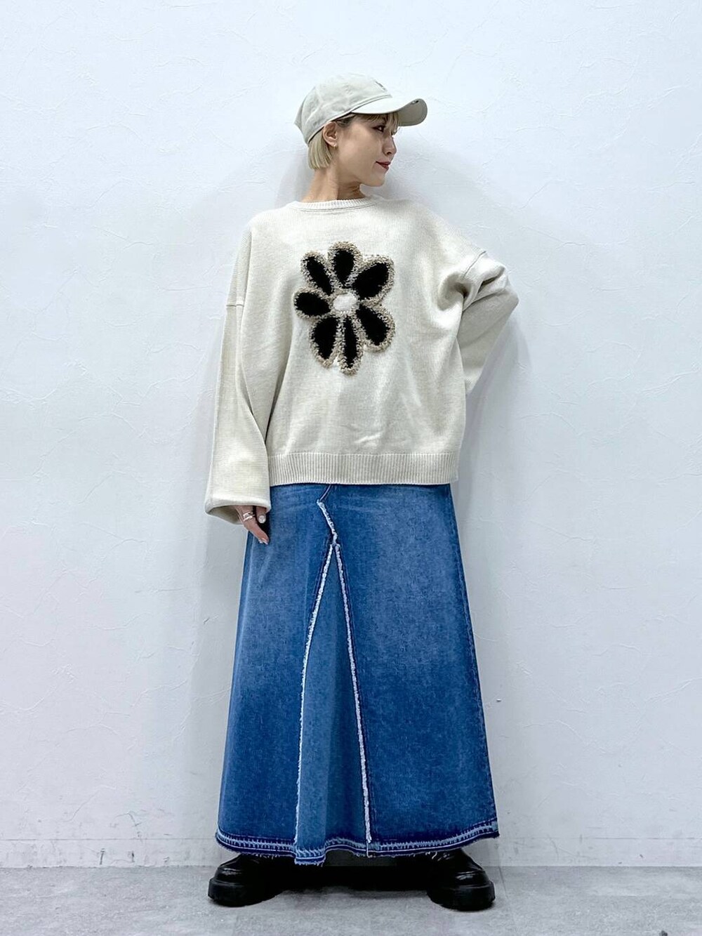 ブルー系のデニムスカート、ホワイト系のニット/セーター、ブラック系のローファーを着用したレディースの冬コーディネートの4枚目の写真