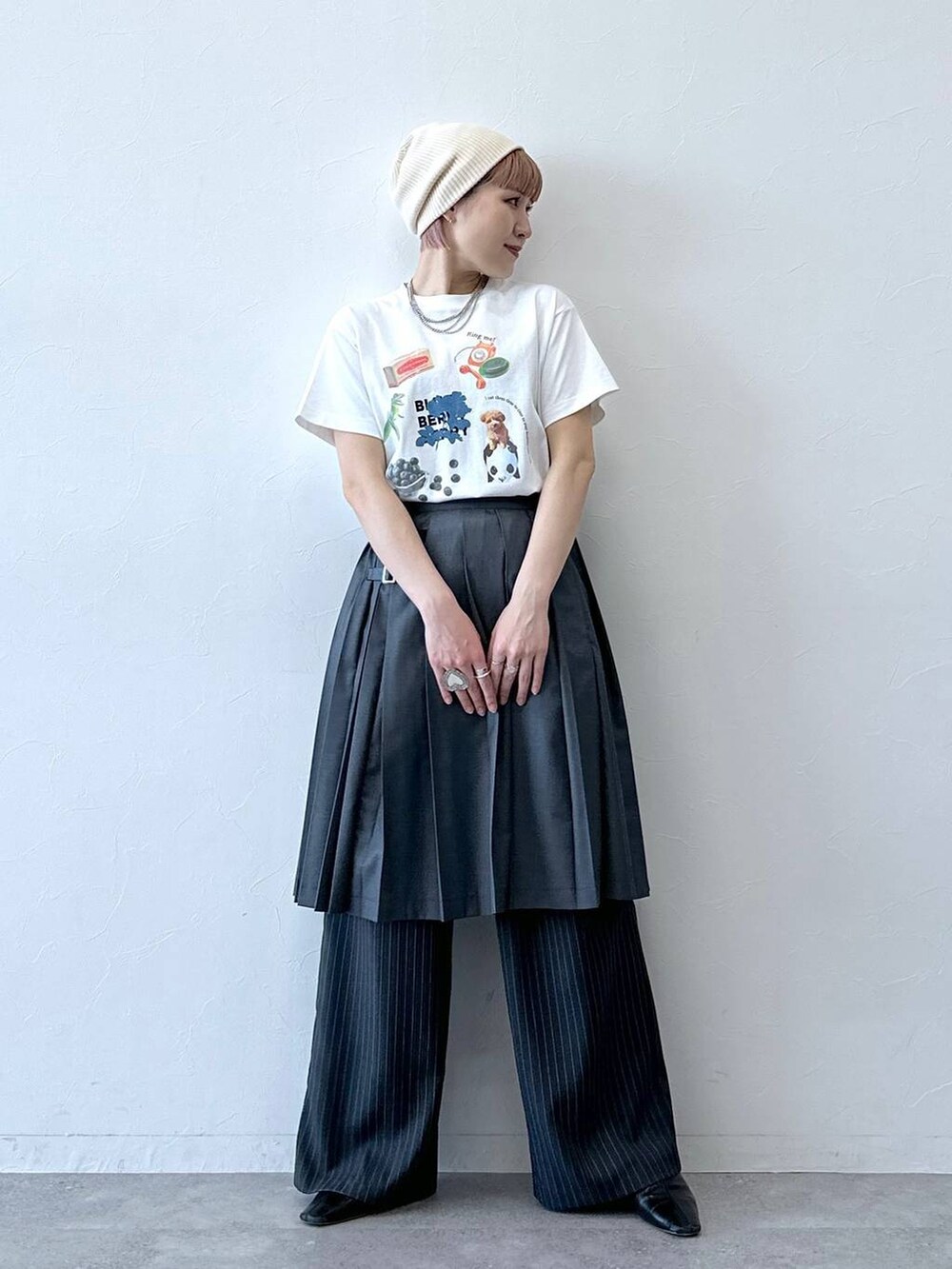 グレー系のスラックス、グレー系のスカート、ホワイト系のTシャツ/カットソーを着用したレディースの春コーディネートの4枚目の写真