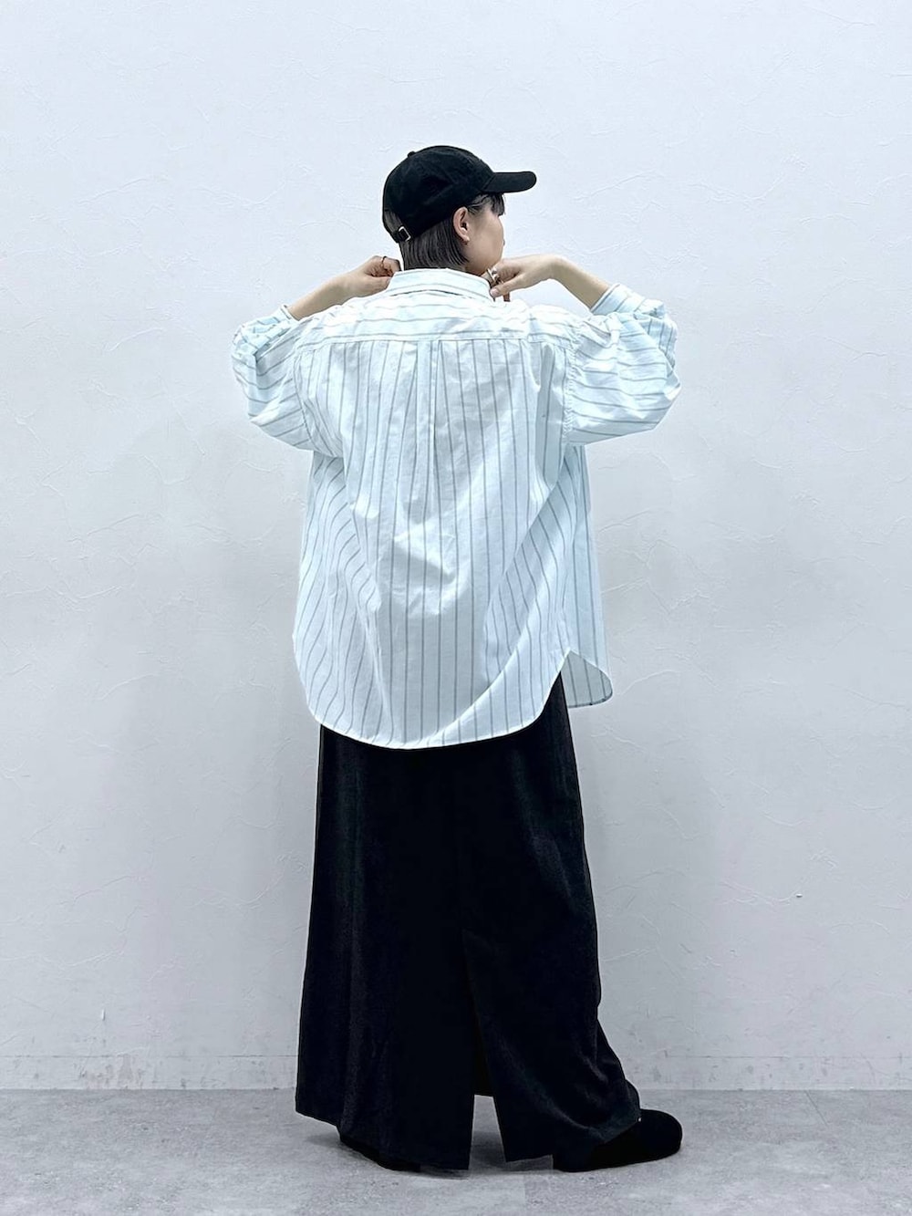 グリーン系のシャツ/ブラウス、ブラック系のモカシン/デッキシューズ、ブラック系のスカートを着用したレディースの春コーディネートの5枚目の写真