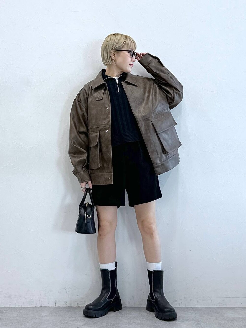 ブラック系のチノパンツ、ブラック系のブーツ、ブラウン系のブルゾンを着用したレディースの冬コーディネートの4枚目の写真