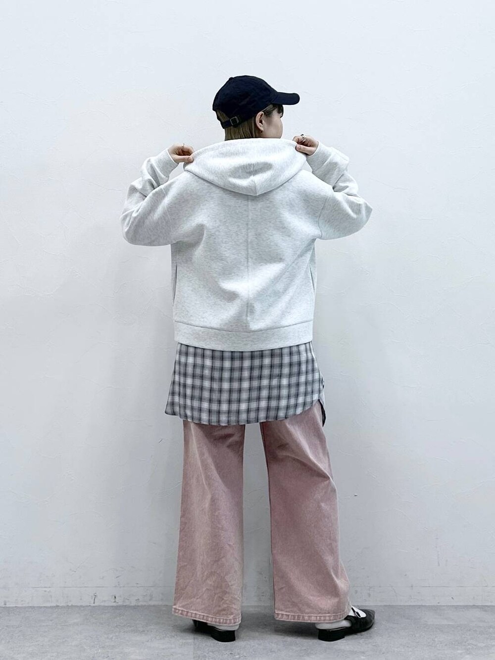 ブラック系のパンプス、ホワイト系のパーカー、ピンク系のデニムパンツを着用したレディースの冬コーディネートの5枚目の写真