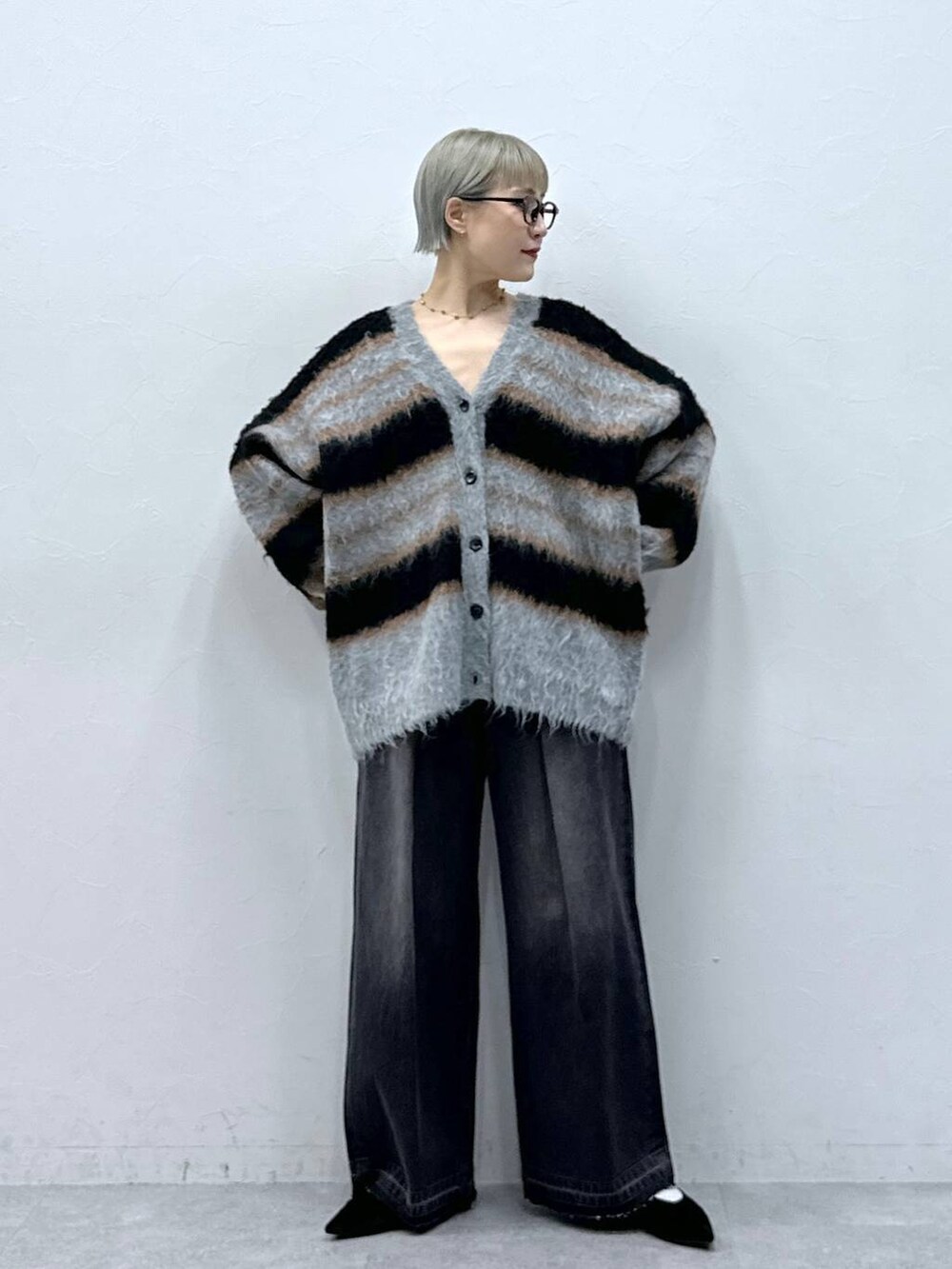 ブラック系のパンプス、ブラック系のカーディガン/ボレロ、ブラック系のデニムパンツを着用したレディースの秋コーディネートの6枚目の写真