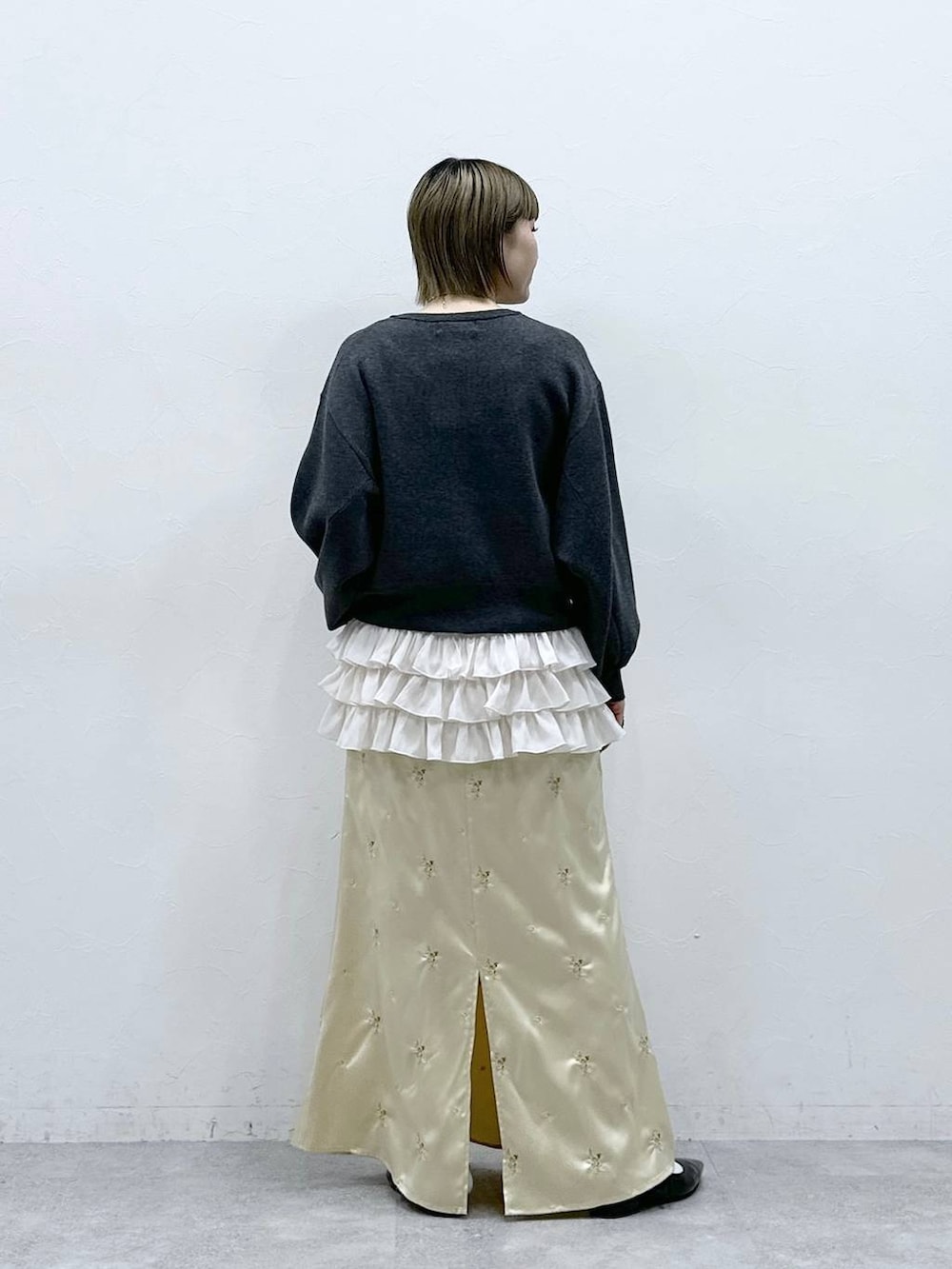 ホワイト系のキャミソール、ブラック系のパンプス、グレー系のカーディガン/ボレロを着用したレディースの冬コーディネートの5枚目の写真