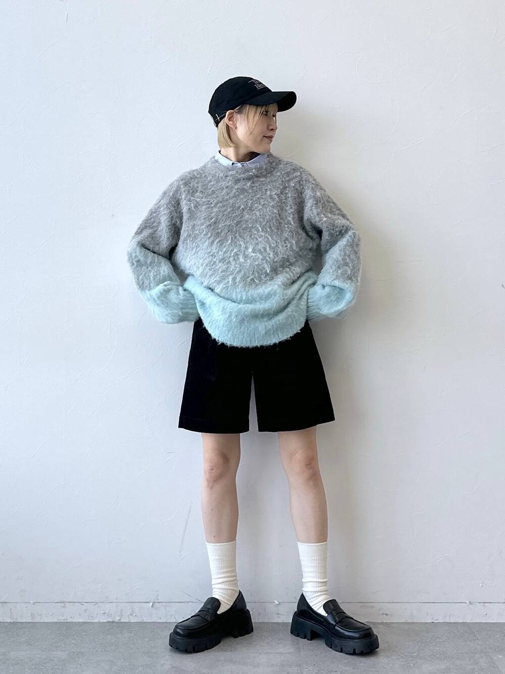 ブラック系のローファー、グレー系のニット/セーター、ブルー系のシャツ/ブラウスを着用したレディースの秋コーディネートの4枚目の写真