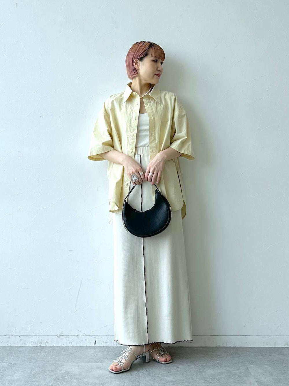 ホワイト系のスカート、イエロー系のシャツ/ブラウスを着用したレディースの春コーディネートの3枚目の写真