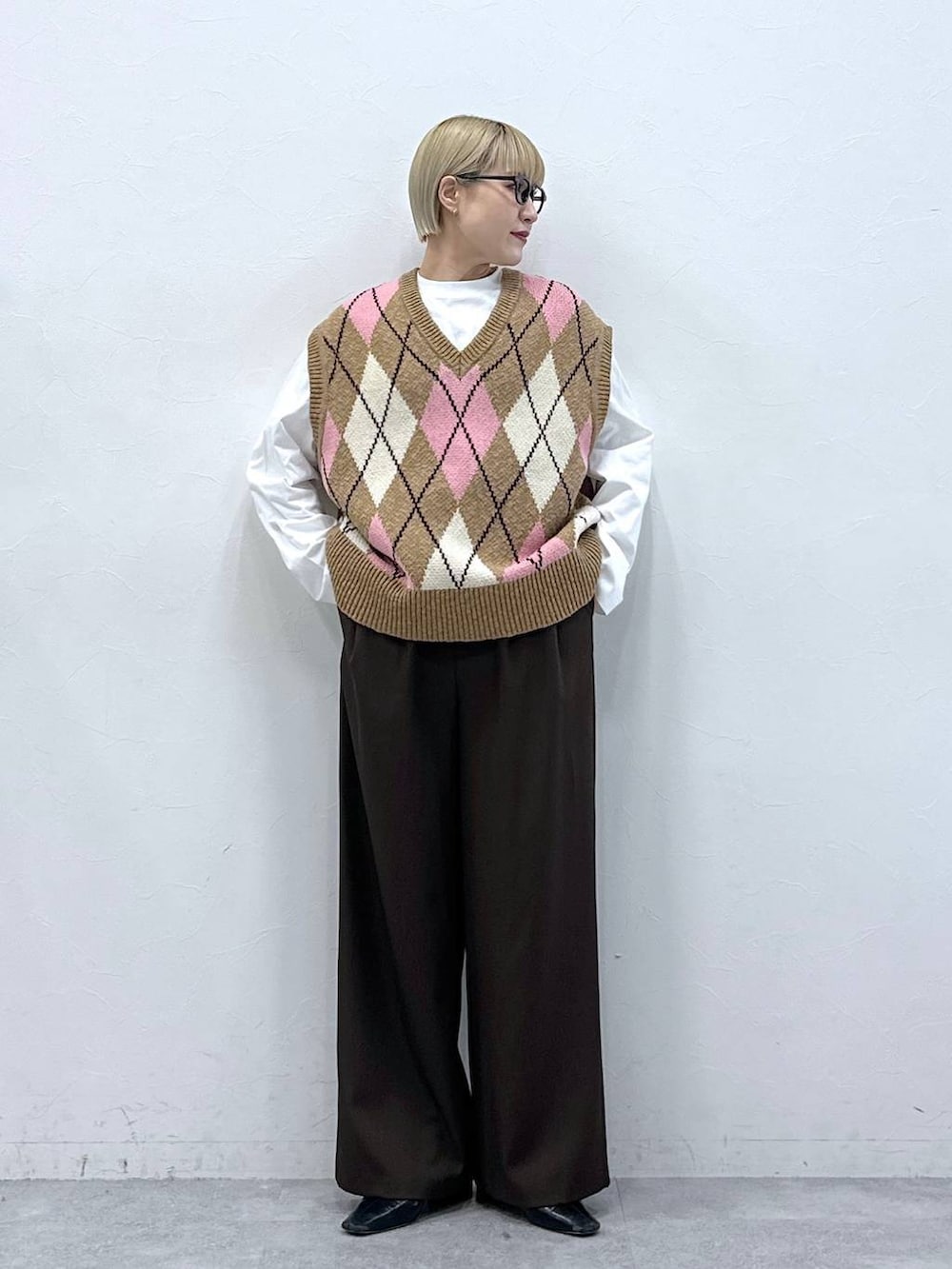 ブラウン系のスラックス、ベージュ系のベスト、ブラック系のサングラスを着用したレディースの冬コーディネートの5枚目の写真