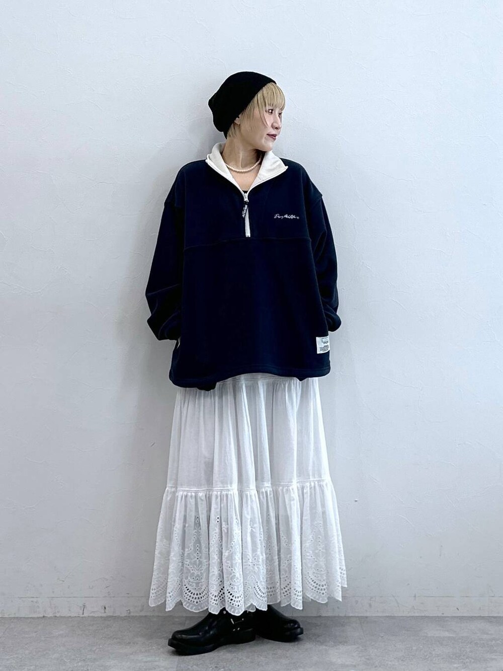 ブルー系のスウェット、ブラック系のブーツ、ホワイト系のスカートを着用したレディースの秋コーディネートの2枚目の写真