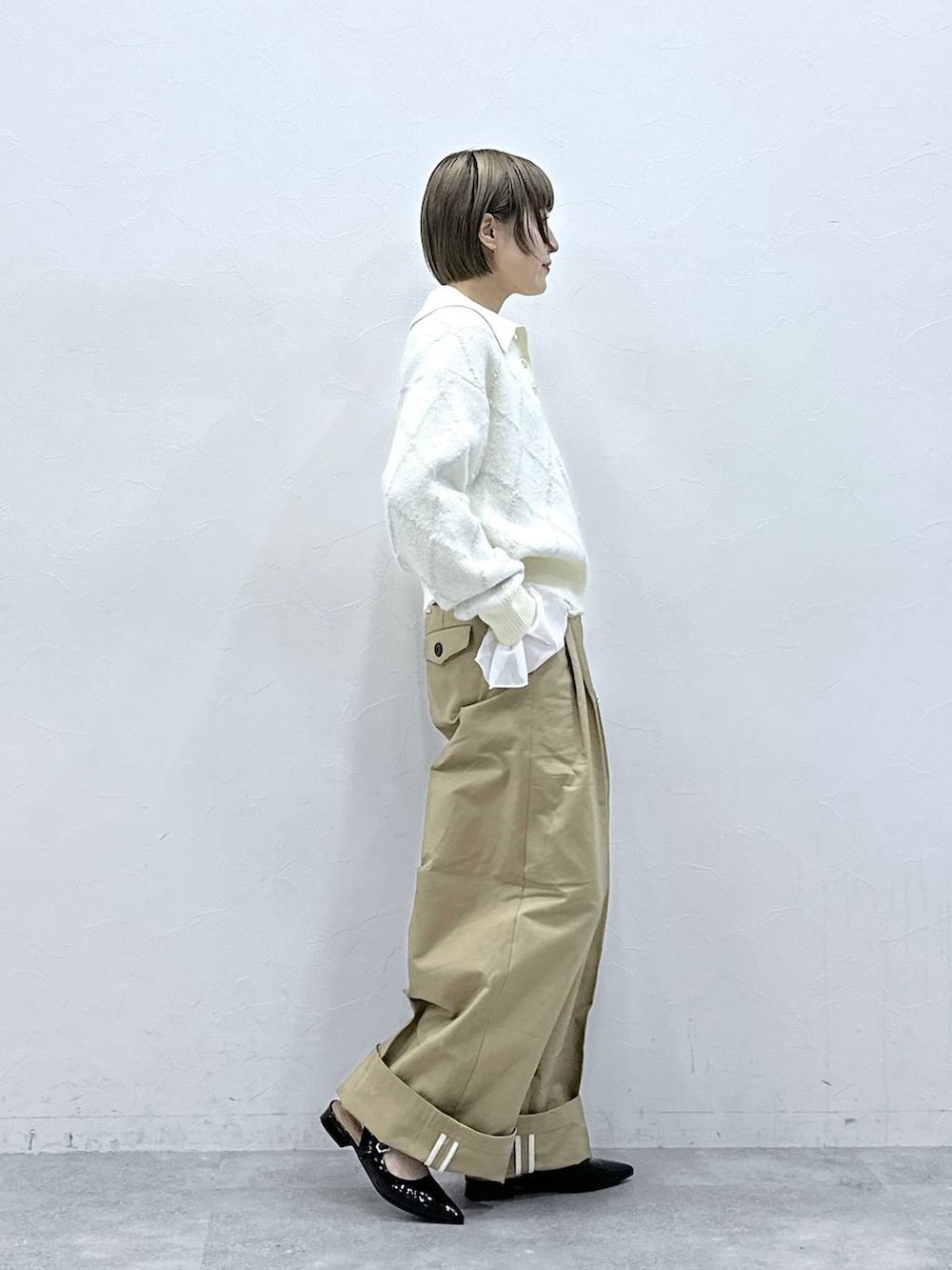 ブラック系のパンプス、ホワイト系のTシャツ/カットソー、ベージュ系のチノパンツを着用したレディースの冬コーディネートの5枚目の写真