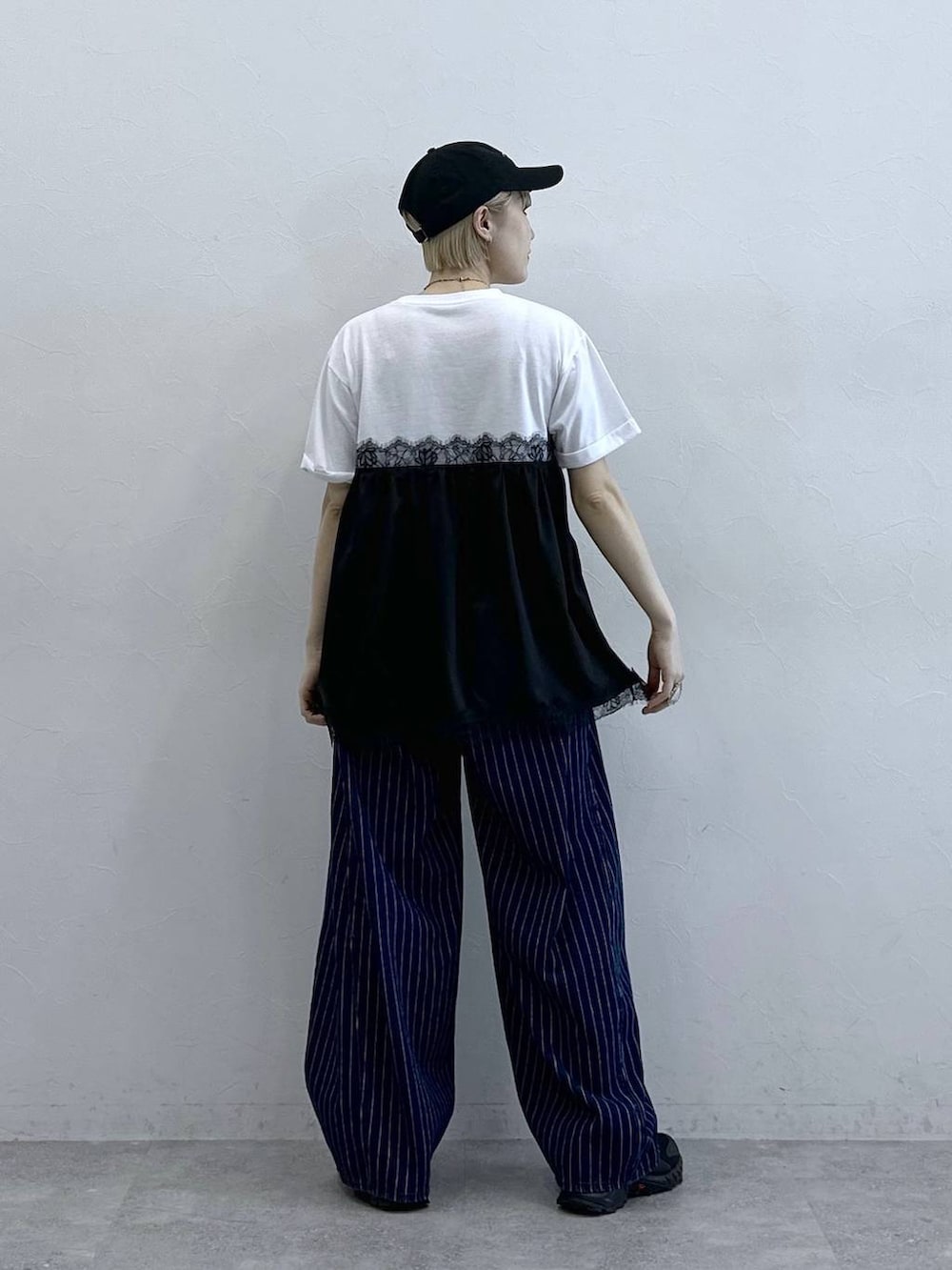 ブラック系のサンダル、ホワイト系のTシャツ/カットソー、ブルー系のデニムパンツを着用したレディースの春コーディネートの5枚目の写真