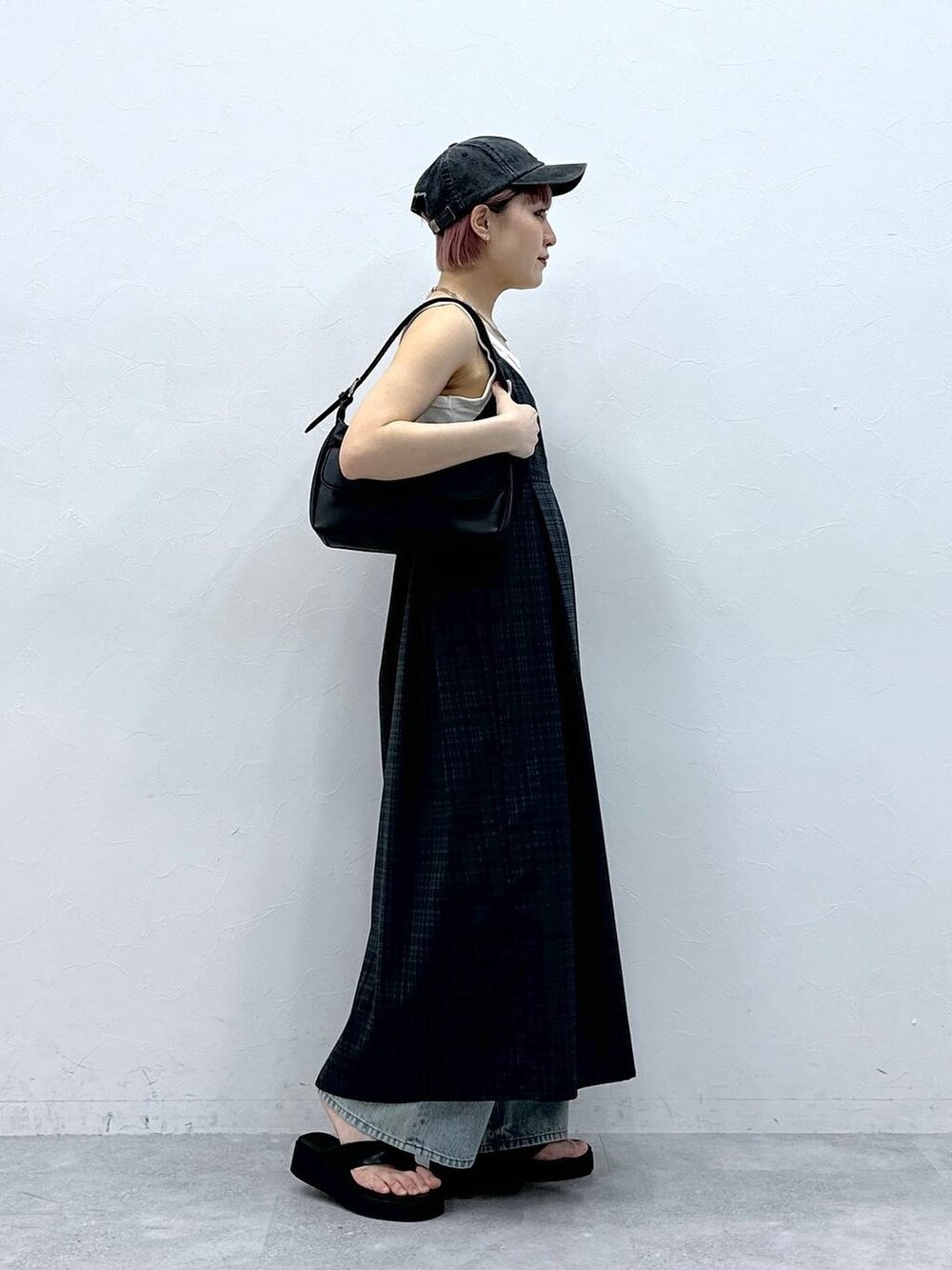 ブルー系のデニムパンツ、グレー系のワンピース、ホワイト系のタンクトップを着用したレディースの春コーディネートの4枚目の写真