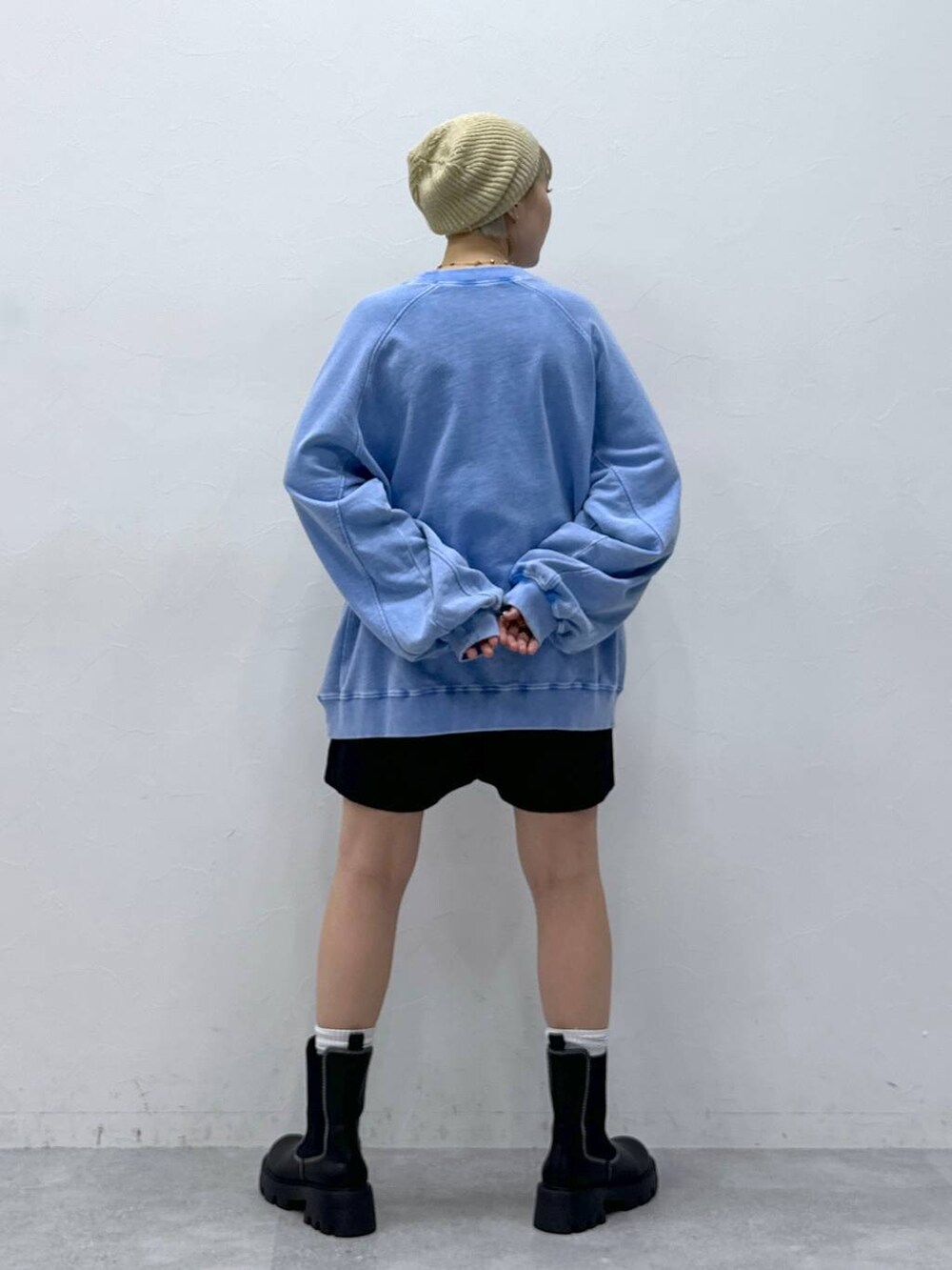 ブラック系のチノパンツ、ブラック系のブーツ、ブルー系のスウェットを着用したレディースの秋コーディネートの5枚目の写真