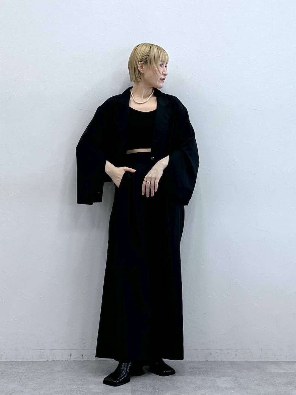 ブラック系のテーラードジャケット、ブラック系のブラジャーを着用したレディースの秋コーディネートの3枚目の写真