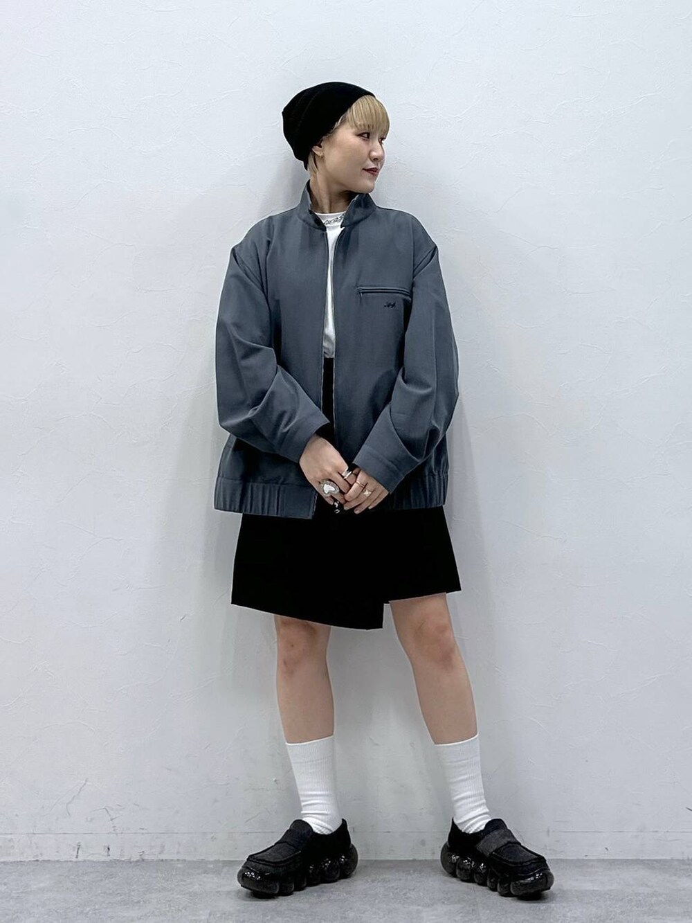 ブラック系のスカート、グレー系のブルゾンを着用したレディースの冬コーディネートの3枚目の写真