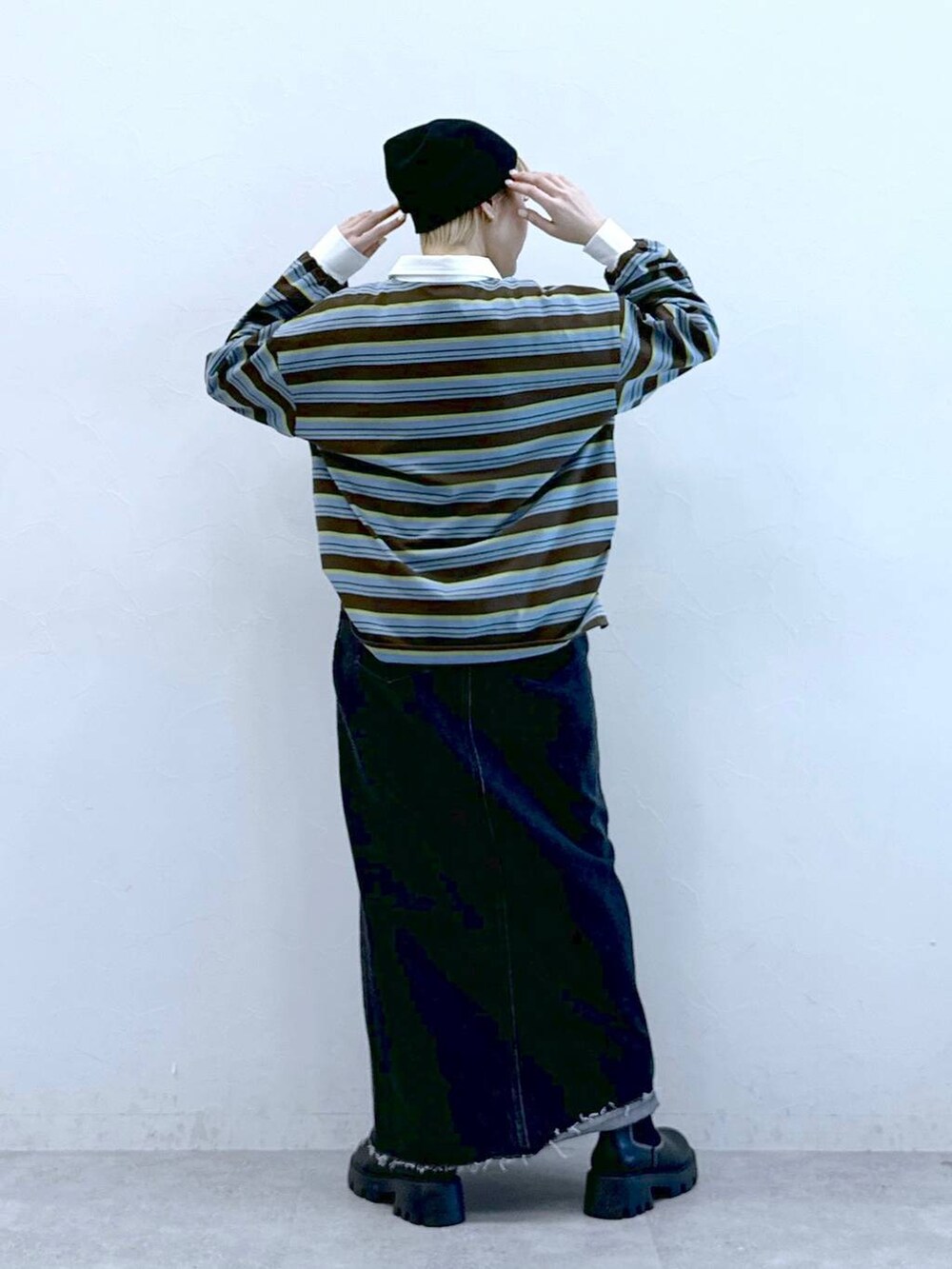 ブラック系のブーツ、ブラック系のデニムスカート、ブラウン系のポロシャツを着用したレディースの冬コーディネートの6枚目の写真