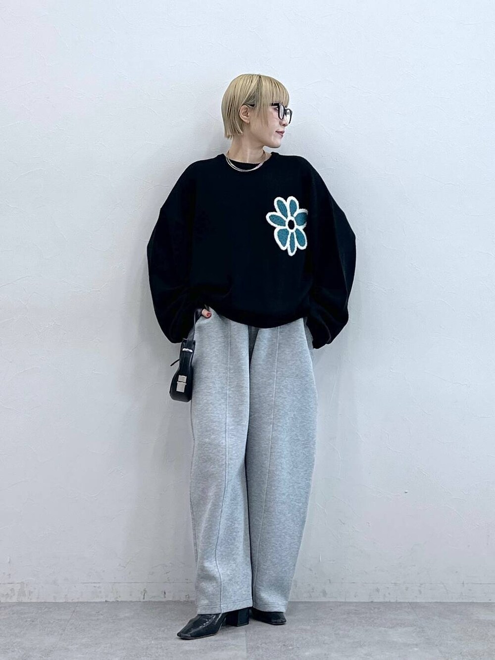 ブラック系のニット/セーター、グレー系のスウェットパンツ、グレー系のメガネを着用したレディースの秋コーディネートの2枚目の写真