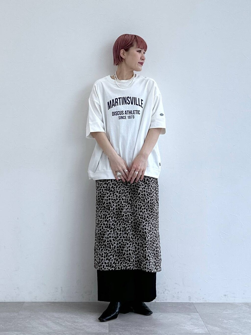 ホワイト系のTシャツ/カットソー、ブラック系のスラックス、ベージュ系のスカートを着用したレディースの春コーディネートの2枚目の写真