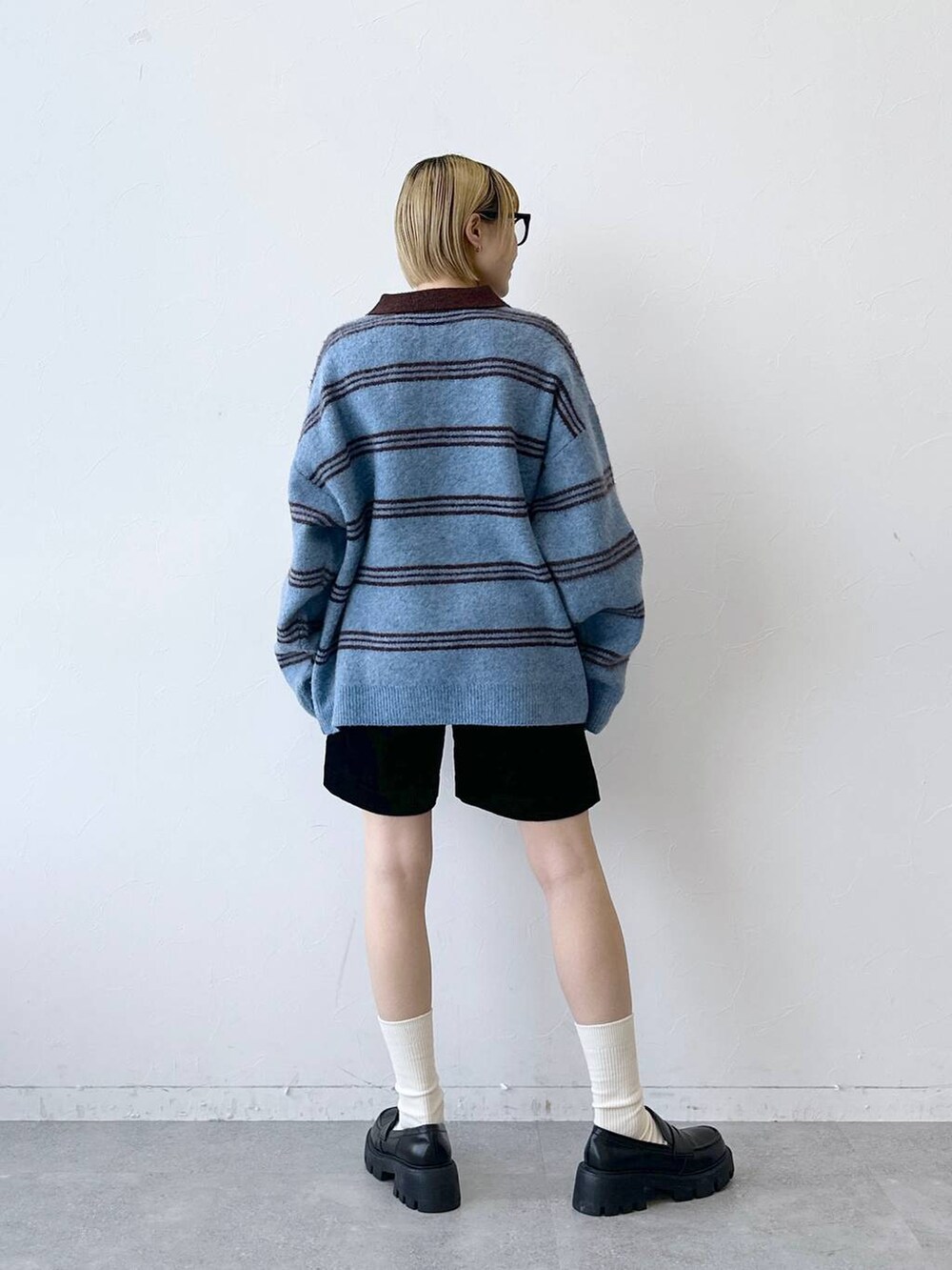 ブラック系のローファー、ブラック系のその他パンツ、ブルー系のポロシャツを着用したレディースの秋コーディネートの7枚目の写真