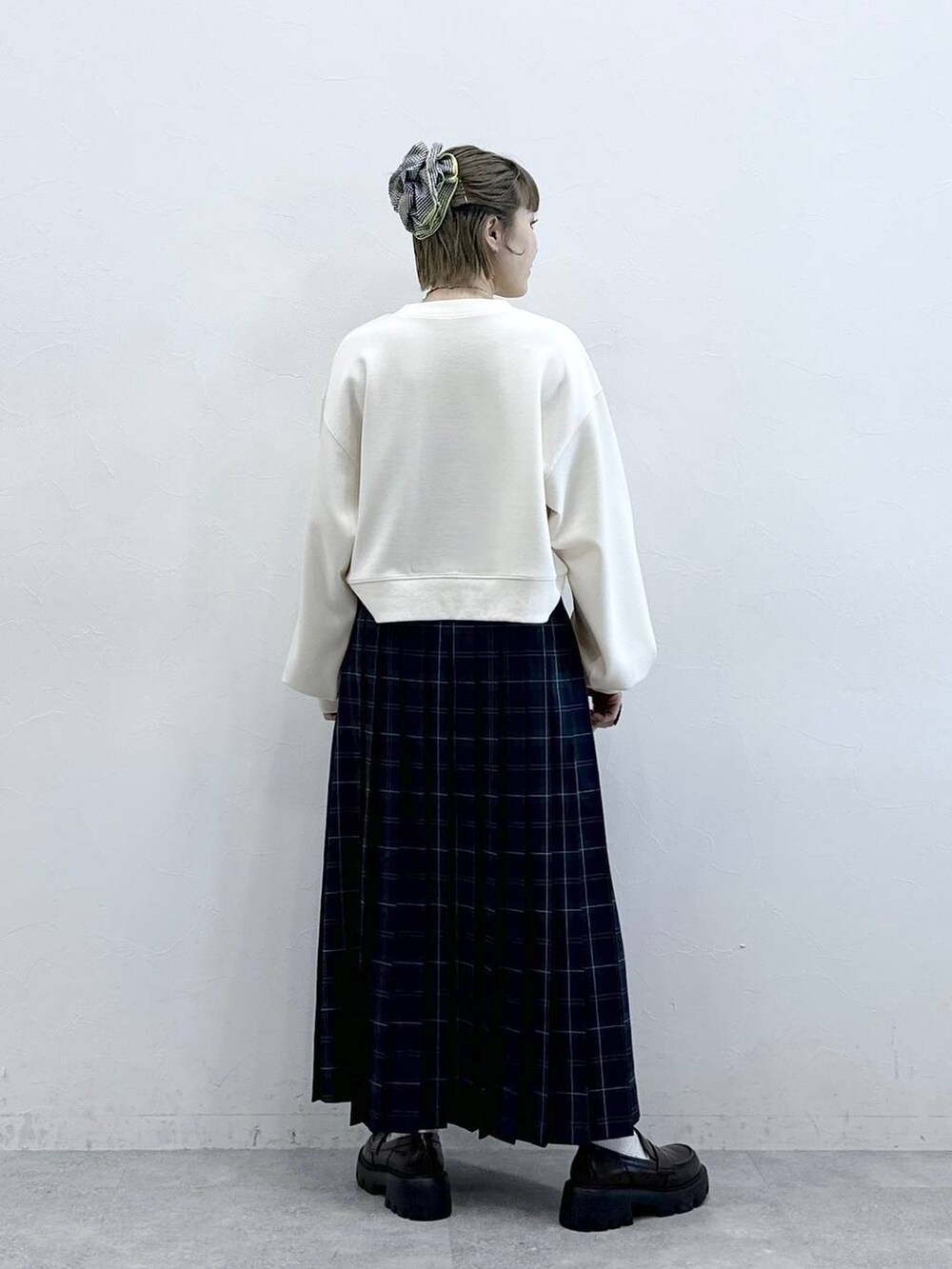 ブラウン系のローファー、グリーン系のスカート、ホワイト系のスウェットを着用したレディースの冬コーディネートの5枚目の写真