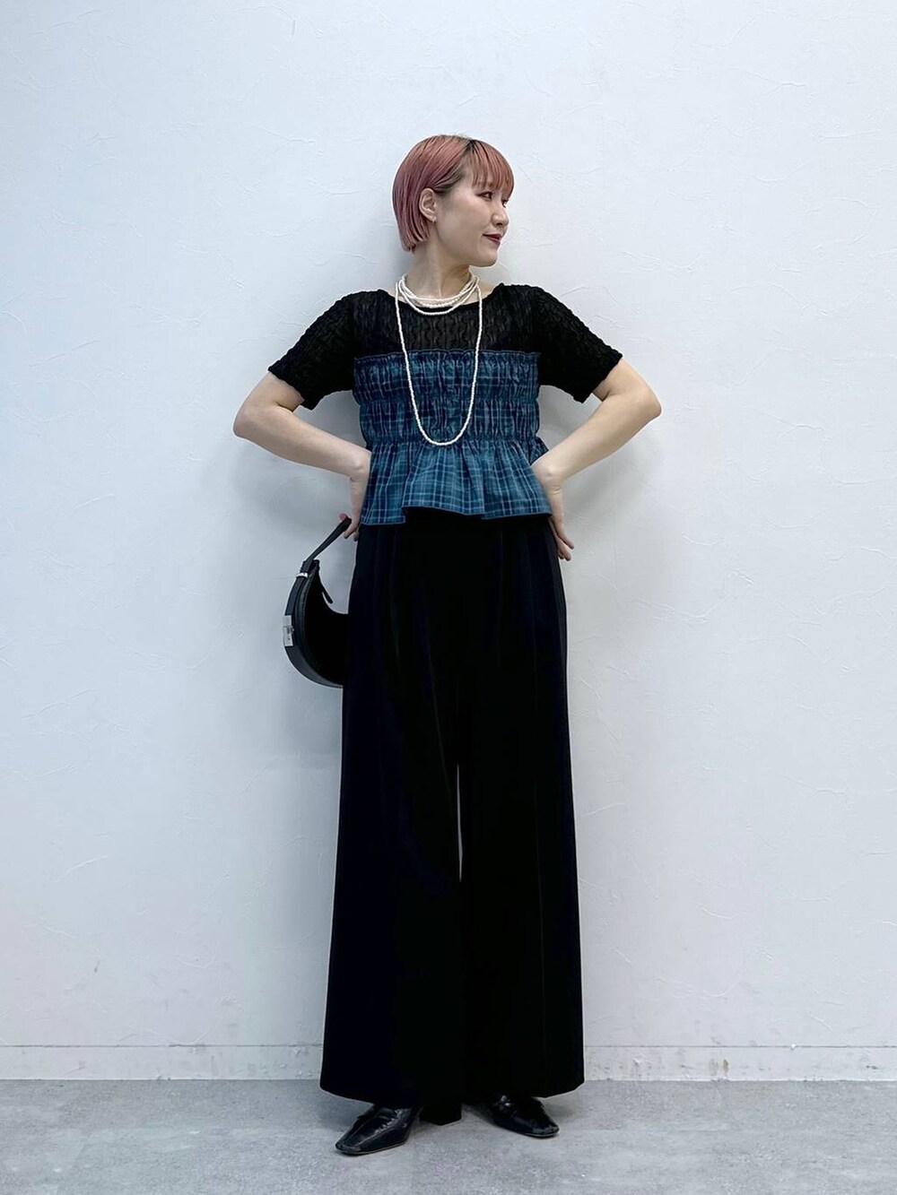 ブラック系のスラックス、ブラック系のTシャツ/カットソーを着用したレディースの春コーディネートの3枚目の写真