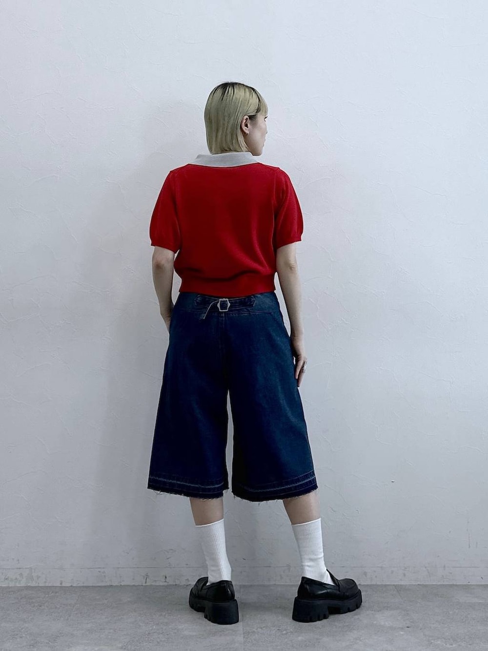 ブルー系のデニムパンツ、ブラック系のローファー、レッド系のポロシャツを着用したレディースの夏コーディネートの5枚目の写真