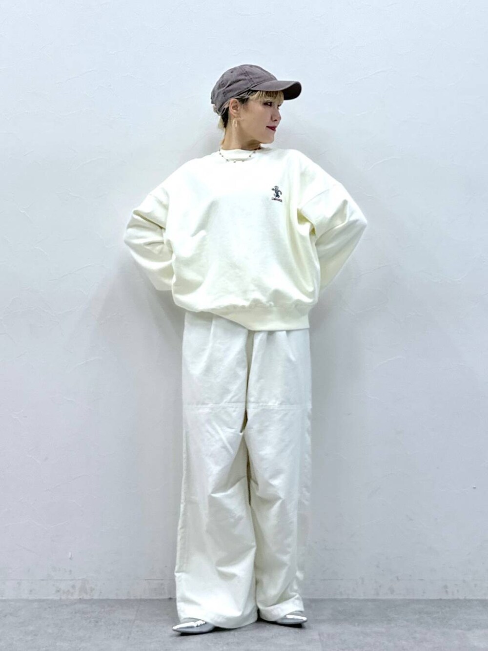 シルバー系のパンプス、ホワイト系のカーゴパンツ、ホワイト系のスウェットを着用したレディースの秋コーディネートの2枚目の写真