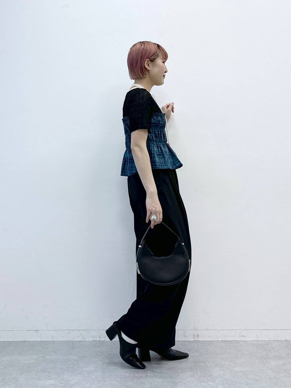 ブラック系のスラックス、ブラック系のTシャツ/カットソーを着用したレディースの春コーディネートの6枚目の写真