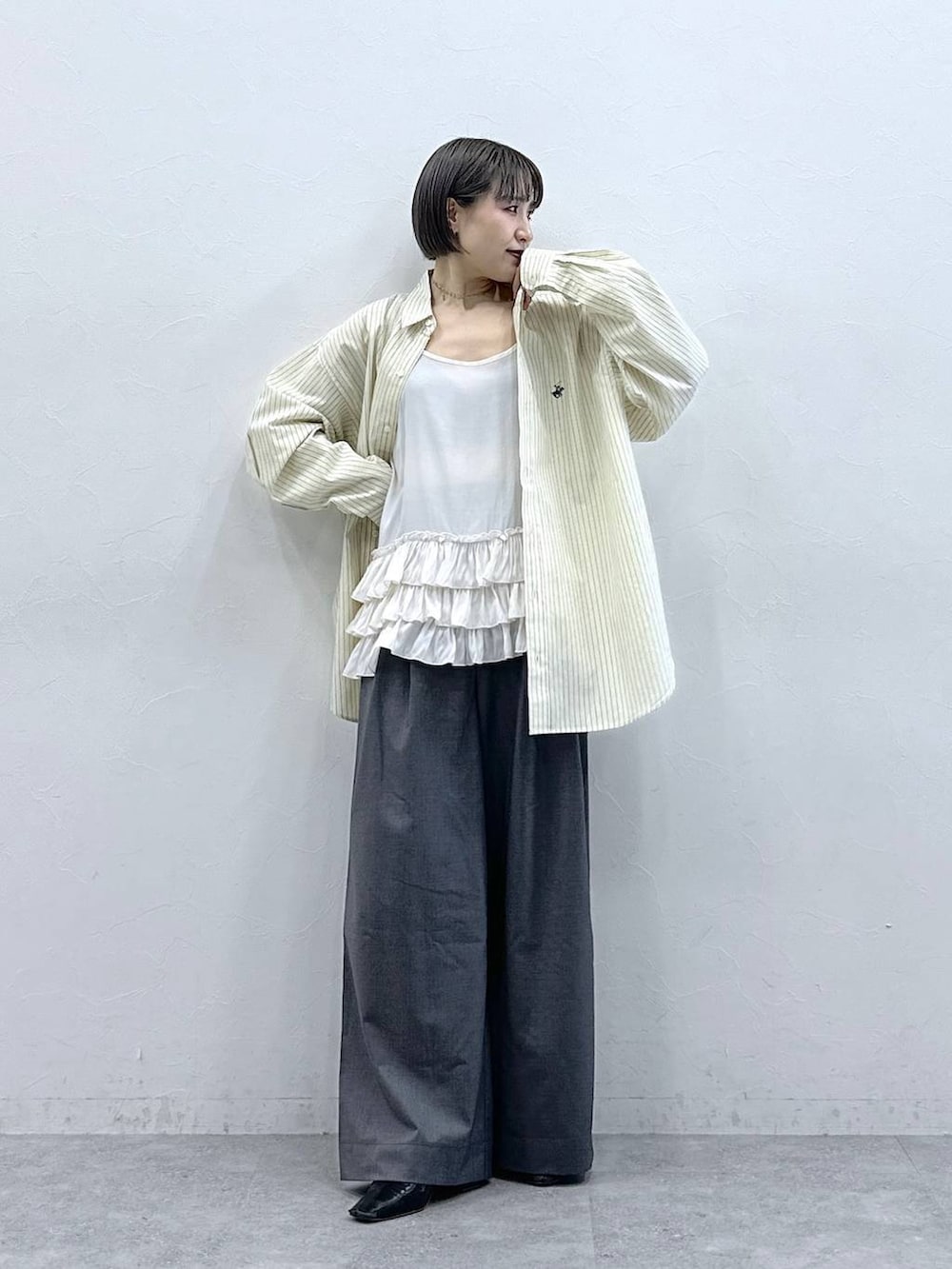 ホワイト系のキャミソール、イエロー系のシャツ/ブラウス、グレー系のスラックスを着用したレディースの春コーディネートの3枚目の写真