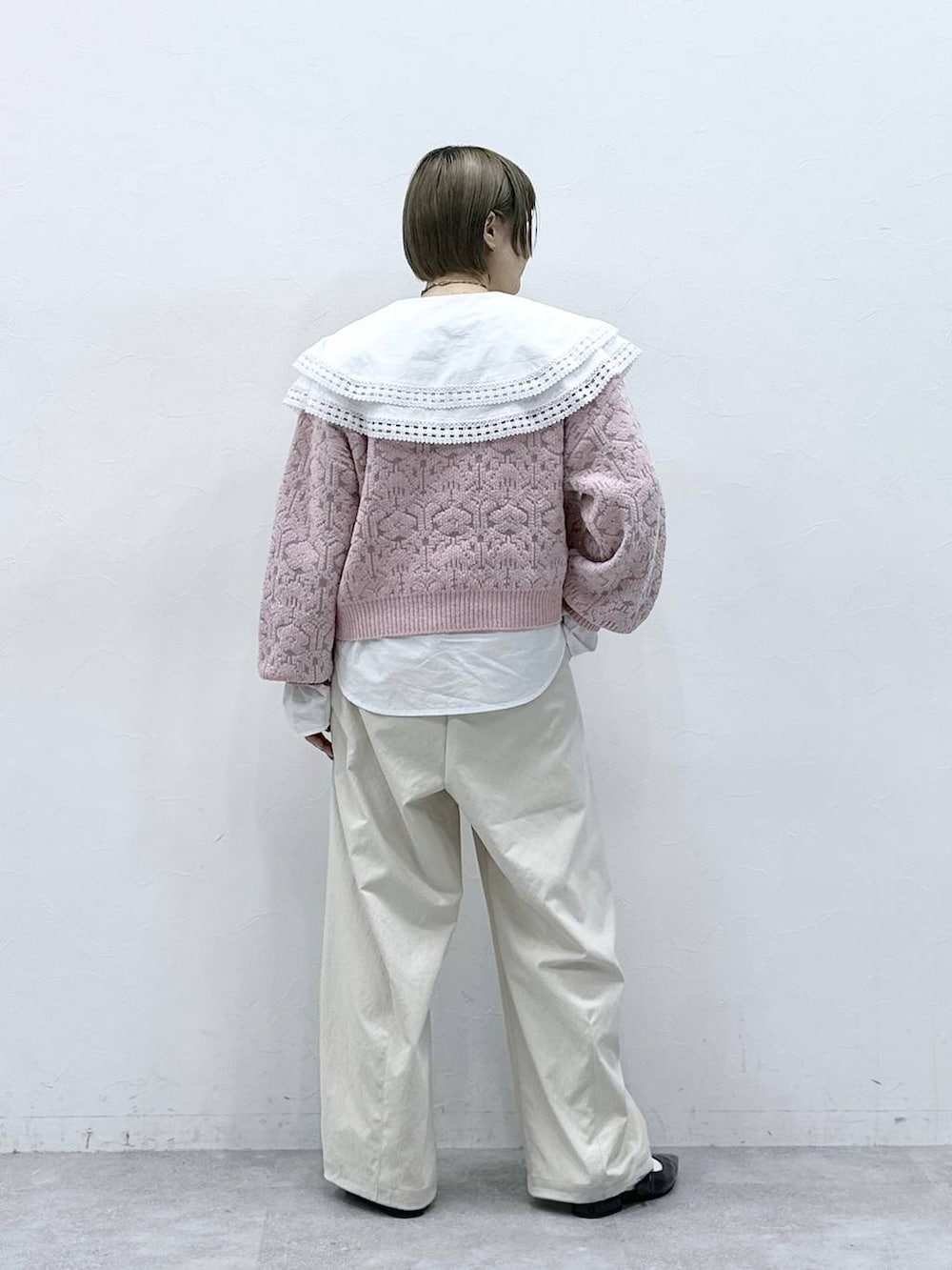 ホワイト系のチノパンツ、ホワイト系のシャツ/ブラウス、ピンク系のニット/セーターを着用したレディースの冬コーディネートの6枚目の写真