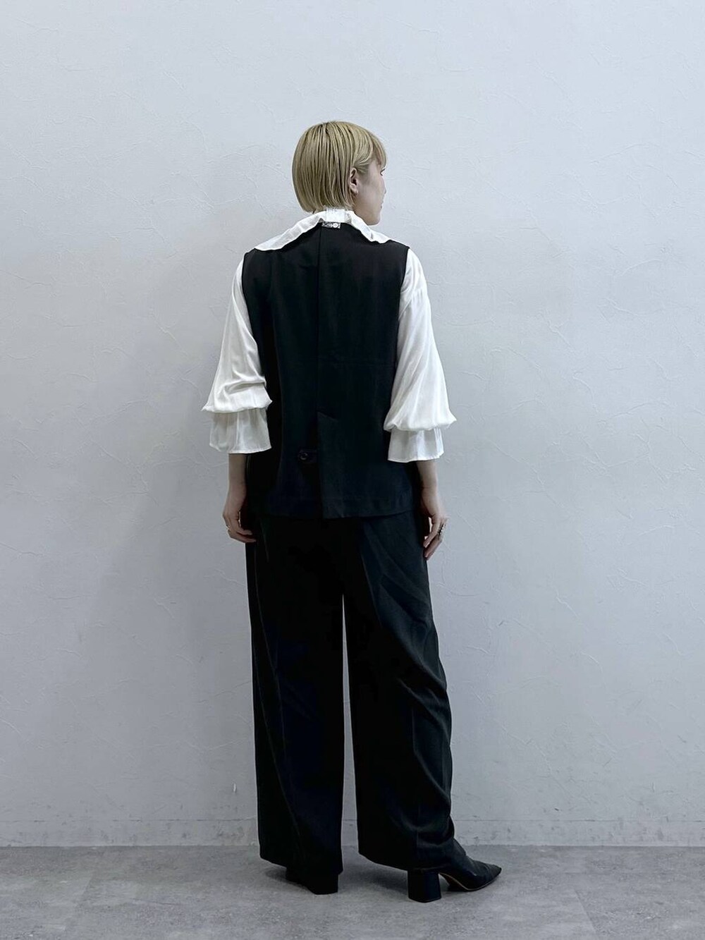 ホワイト系のシャツ/ブラウス、グレー系のスラックス、グレー系のベストを着用したレディースの春コーディネートの6枚目の写真