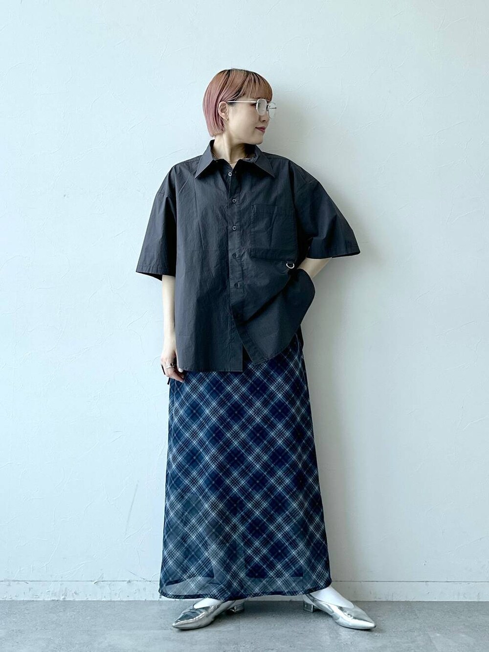 ブルー系のスカート、グレー系のシャツ/ブラウス、ブラック系のメガネを着用したレディースの春コーディネートの2枚目の写真