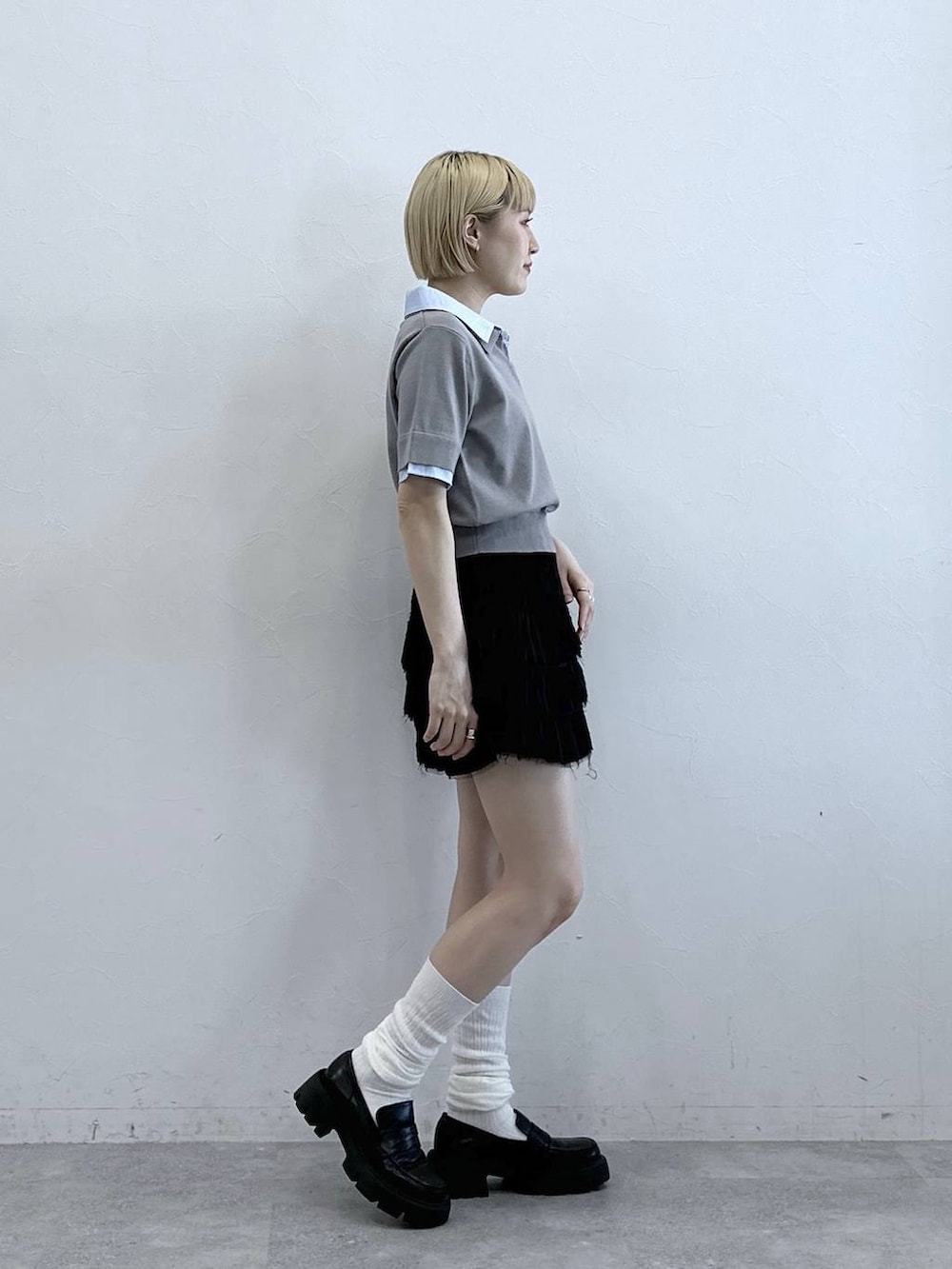 ブラック系のスカート、グレー系のシャツ/ブラウスを着用したレディースの春コーディネートの4枚目の写真